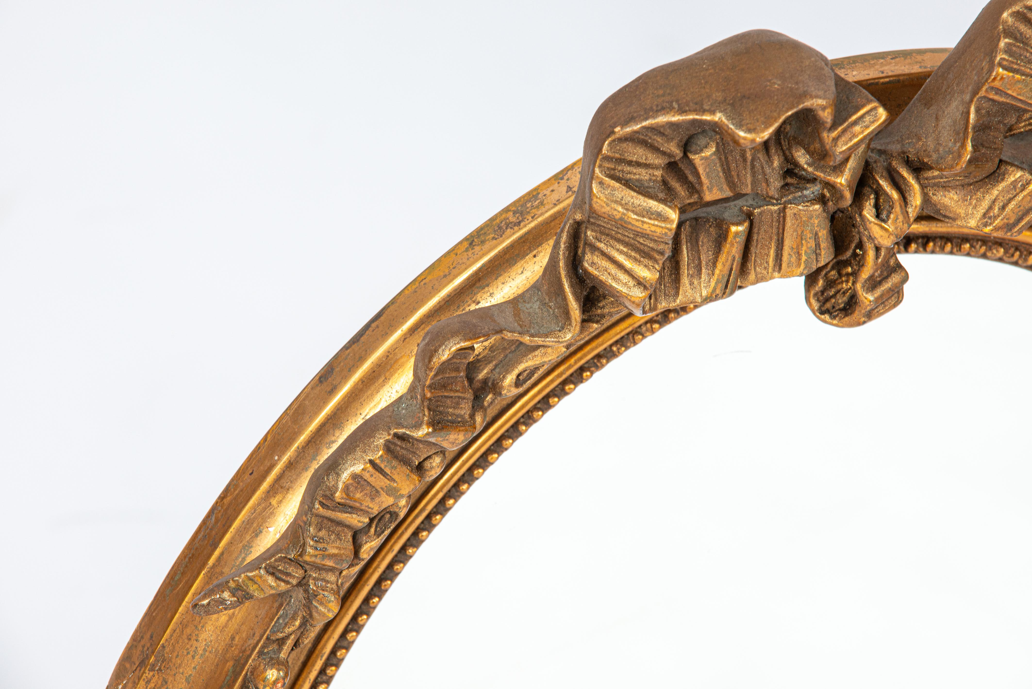 Français Antique début du 20e siècle, miroir à ruban ovale à nœuds en or doré français. en vente
