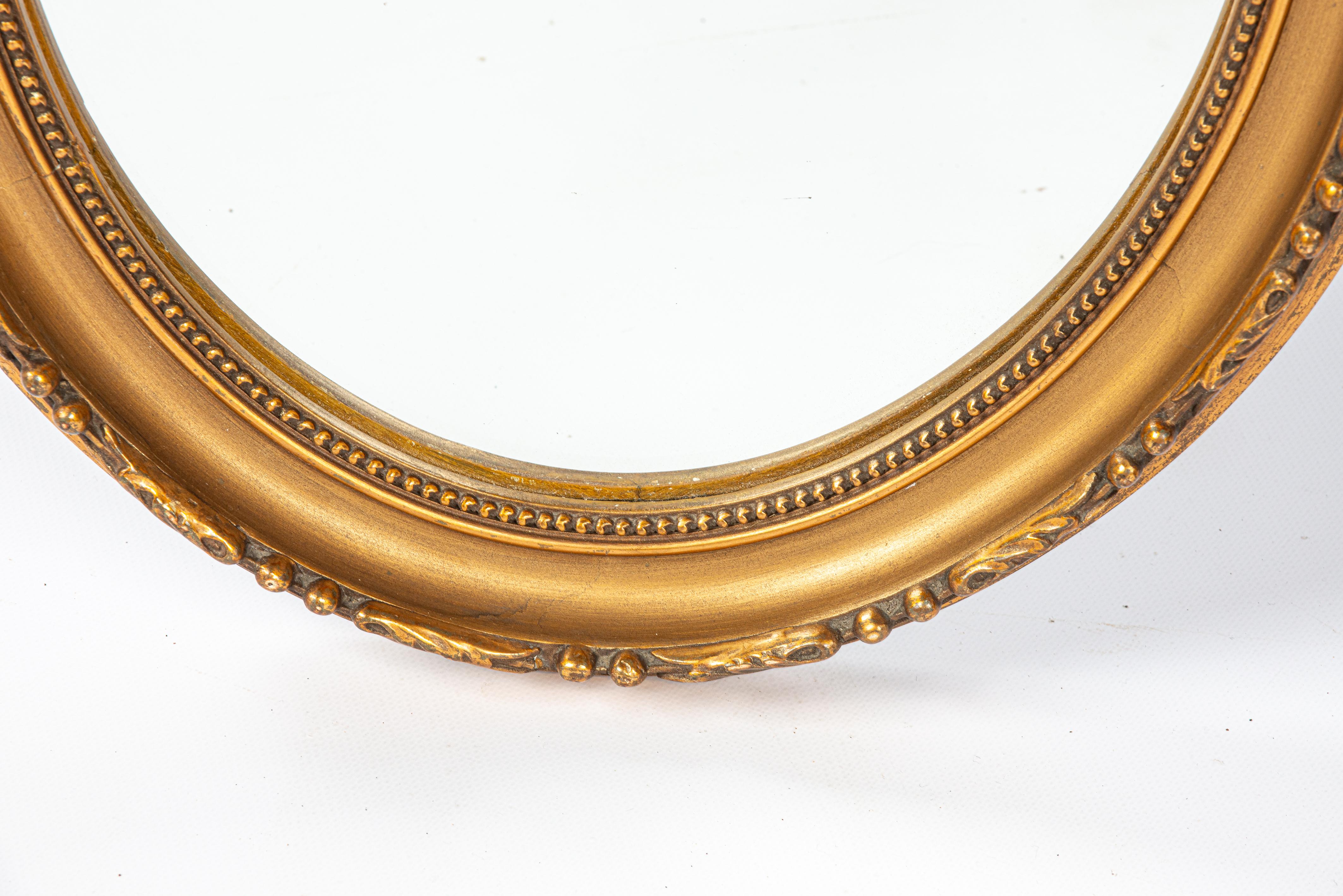 Doré Antique début du 20e siècle, miroir à ruban ovale à nœuds en or doré français. en vente