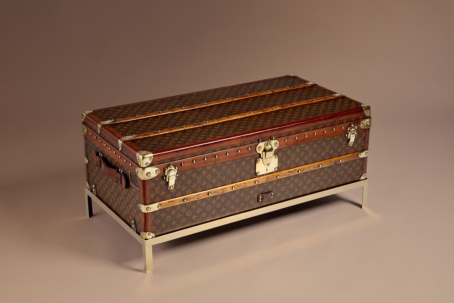 Diese beeindruckende Louis Vuitton-Truhe zeichnet sich durch ein handgesticktes Monogram-Canvas, eine helle, honigfarbene Lozine-Bordüre und von Louis Vuitton geprägte, massive Messingschlösser, Spangen und Nieten aus. Außerdem hat sie große