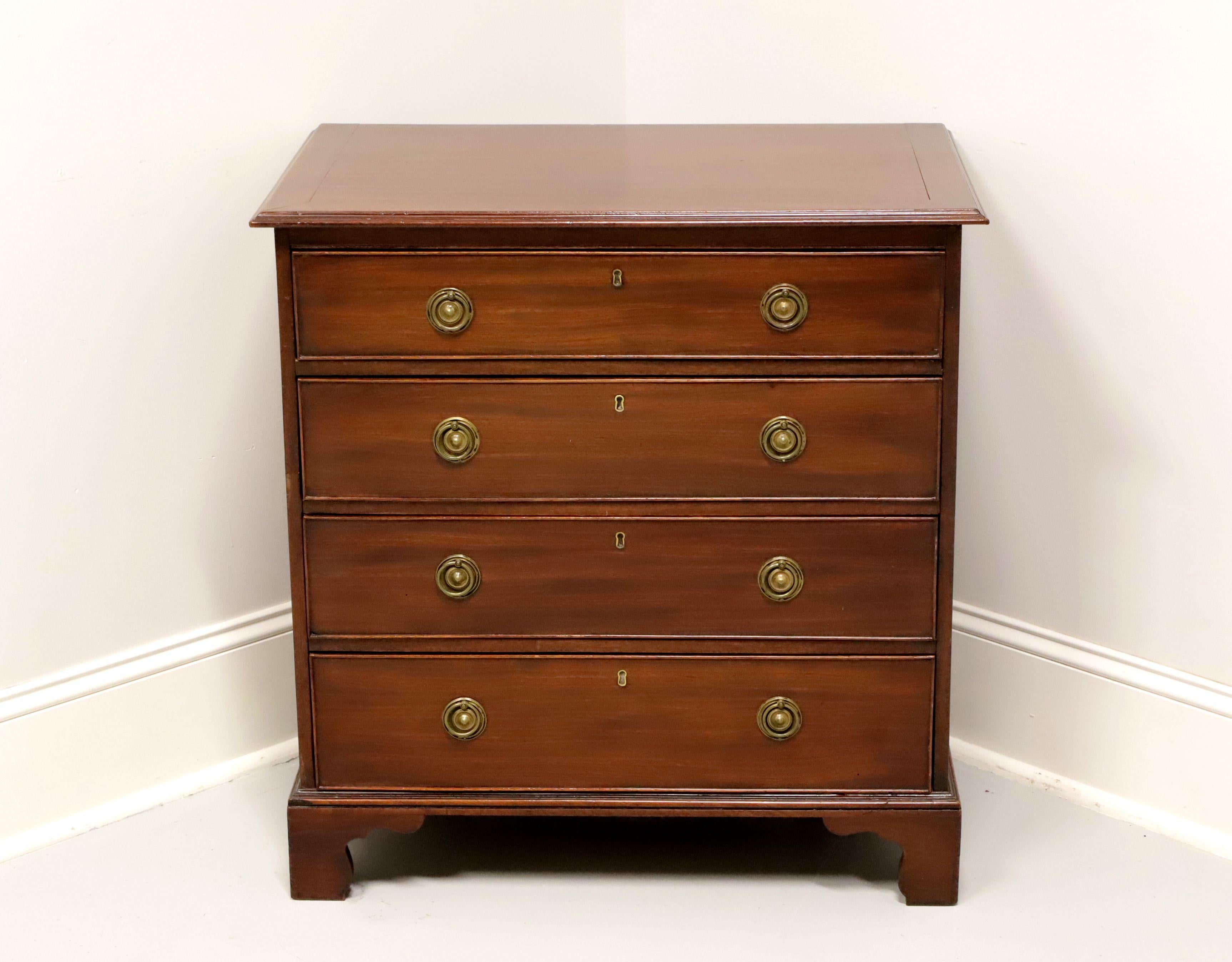 An antique Georgian style bedside chest, unbranded. Solid mahogany with banded top, brass hardware and bracket feet. Features four drawers of dovetail construction with faux keyhole escutcheons. Made in the USA, in the early 20th Century.

Measures: