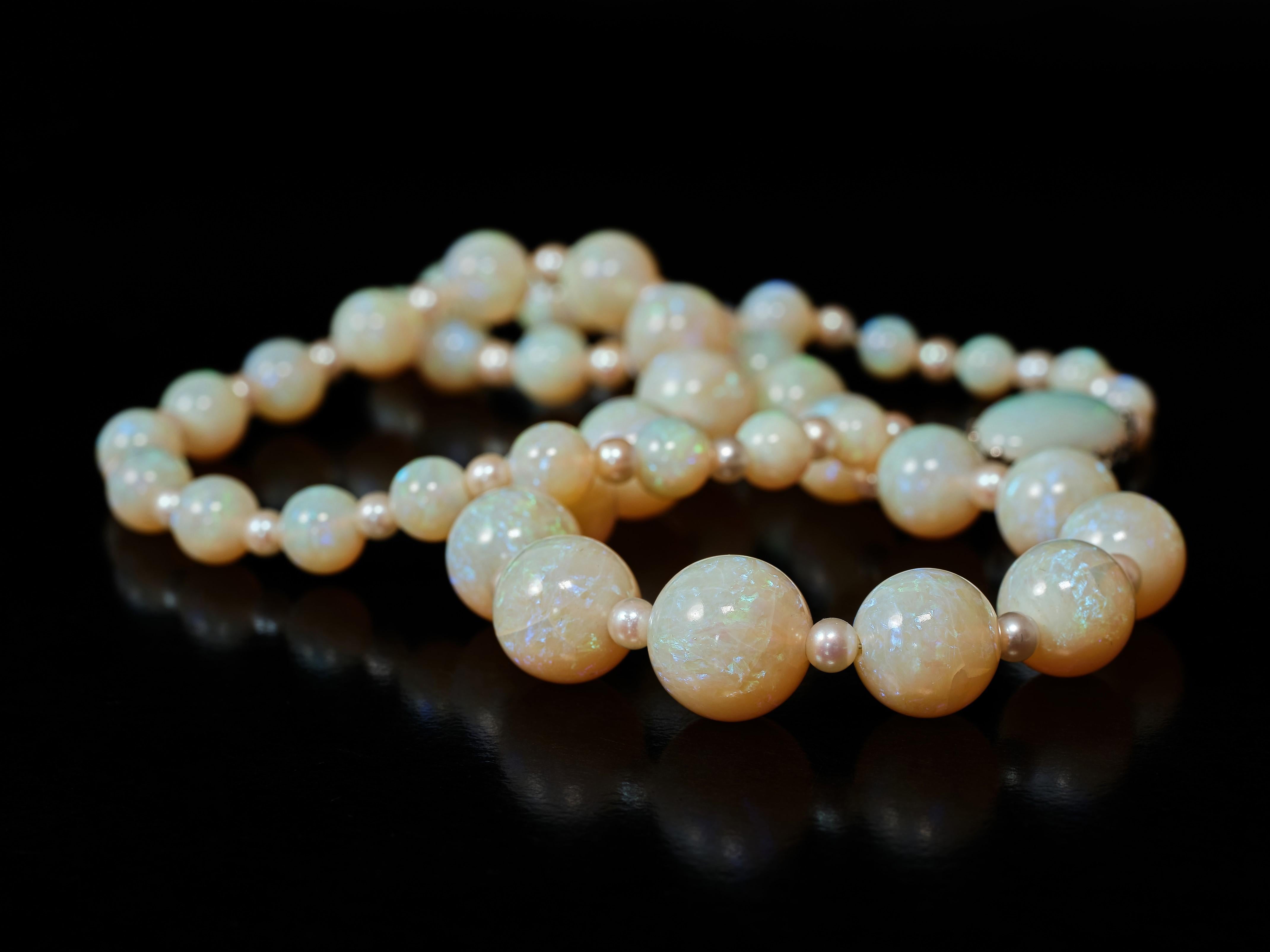 42 wunderschöne, sanft abgestufte, vielfarbige Opalperlen, die mit Blitzen durchsetzt sind, wechseln sich mit kleinen, gleichmäßigen Perlen ab, um diese bezaubernde Halskette zu schaffen. Die Perlen reichen von 5 Millimetern bis zu beeindruckenden
