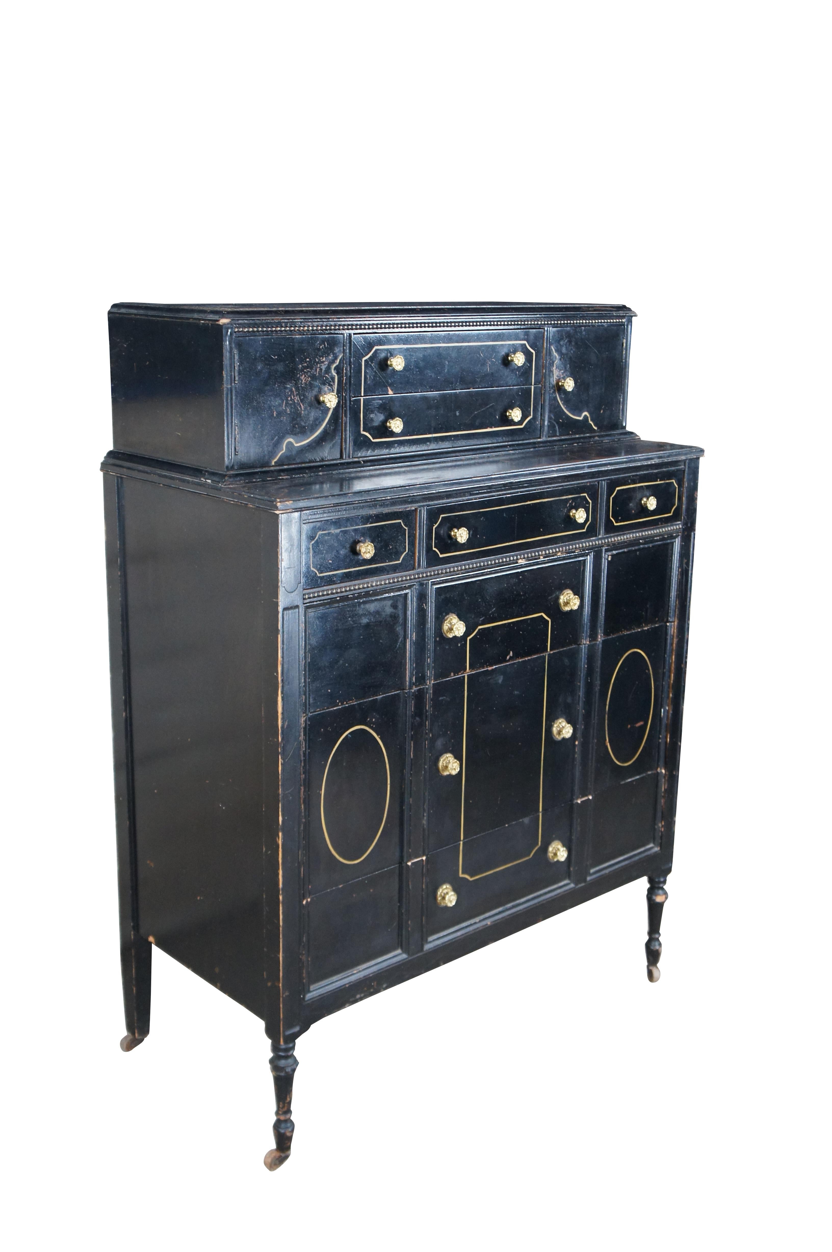 Late Victorian style mahogany painted tall boy chest. Finished in black with gold painted accents. Features four dovetailed drawers and a stepback top with two smaller central drawers flanked by outer cabinets. The drawers / cabinets have gold