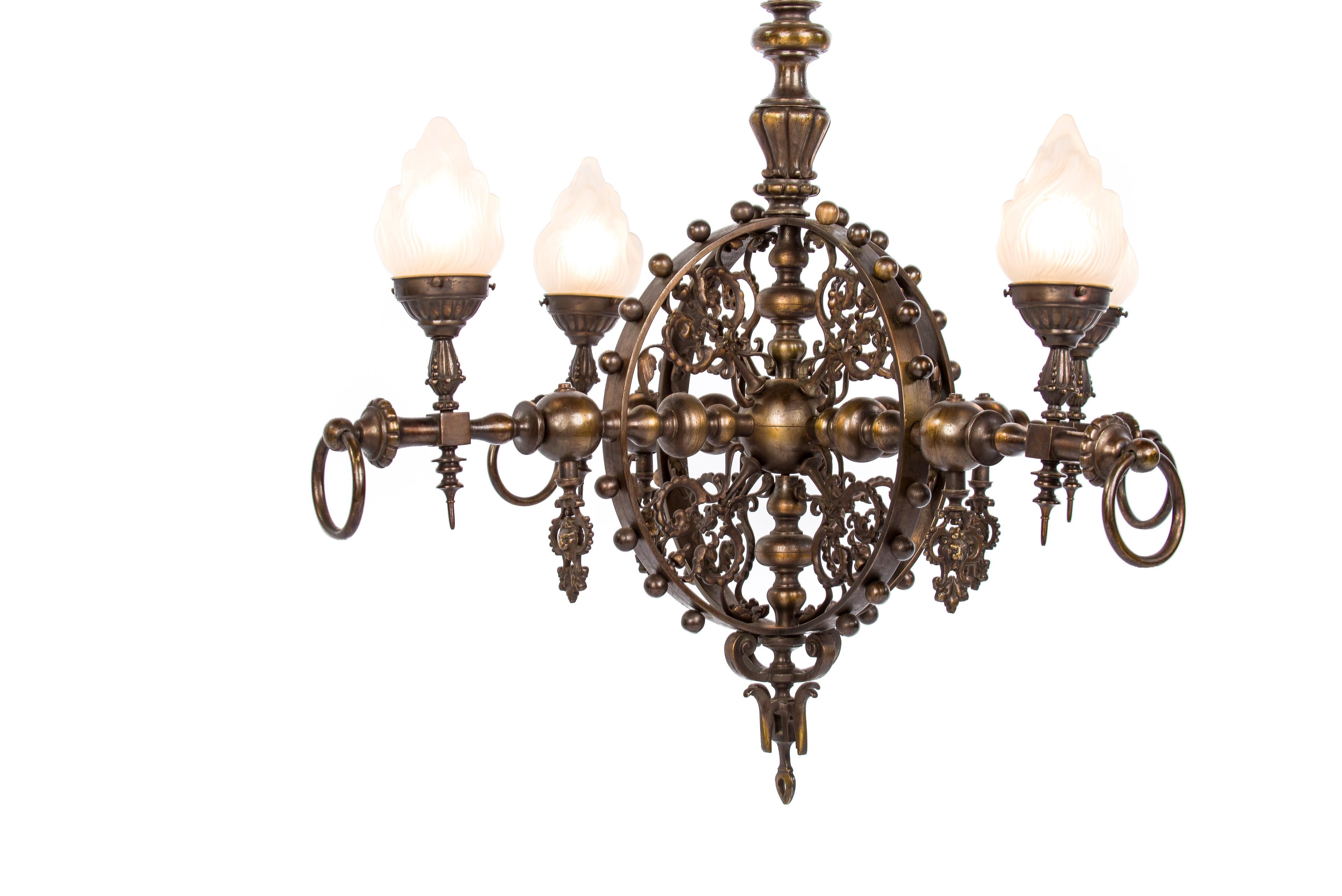 This unique chandelier was made in France in the Provence of Brittany in the early 20th century around 1910. It is completely made of patinated bronze and it was made for gaslighting. 
The chandelier has a circular design typical for the Brittany