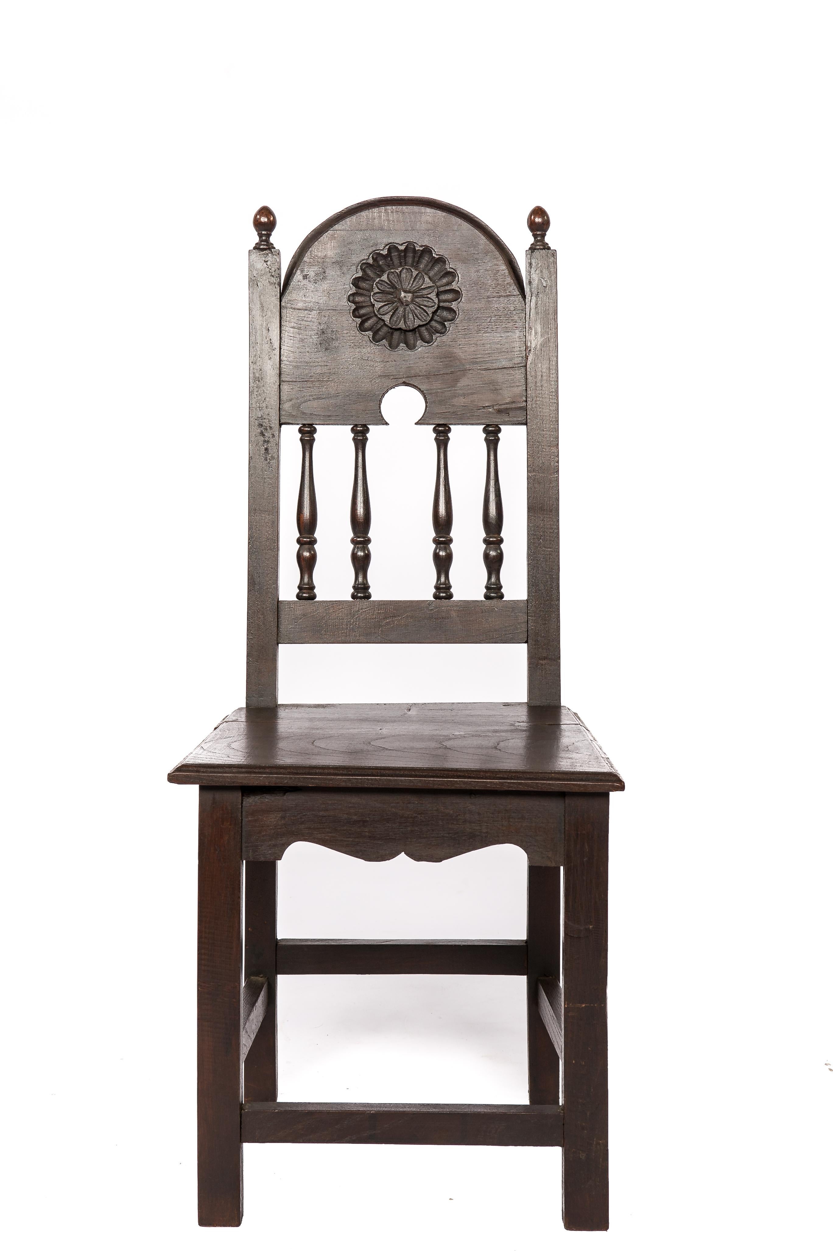On offer here is a beautiful set of four identical chairs, crafted from solid chestnut wood in early 20th-century Spain. These chairs are a testament to Spanish craftsmanship and feature a timeless design that seamlessly blends elegance and