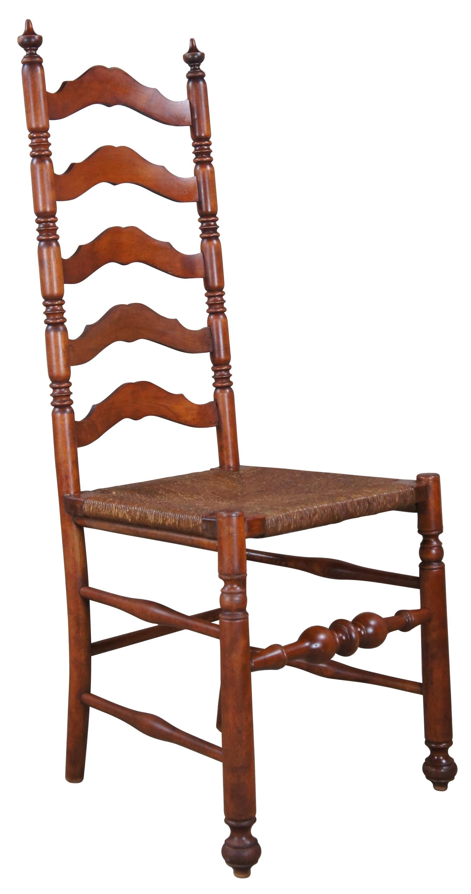 A lovely early 20th century shaker side chair. Made from oak with a serpentine ladder back. Features ripped stiles, spire finials and a rush seat. Legs are turned with shapely stretchers.