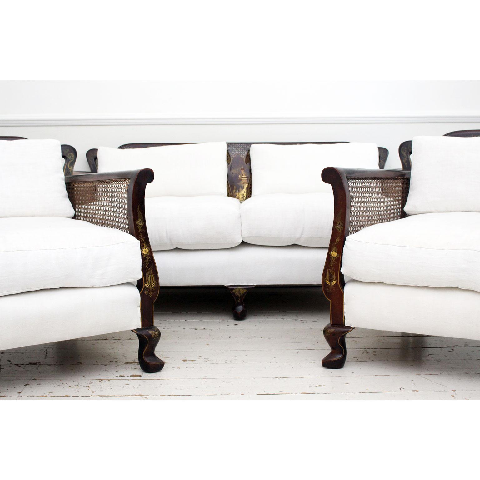 This very decorative early 1900s three piece bergere suite, comprising a sofa and pair of armchairs, is beautifully shaped with generous proportions and slipper feet. The walnut has a lovely warm patina. Each piece is embellished with Chinoiserie