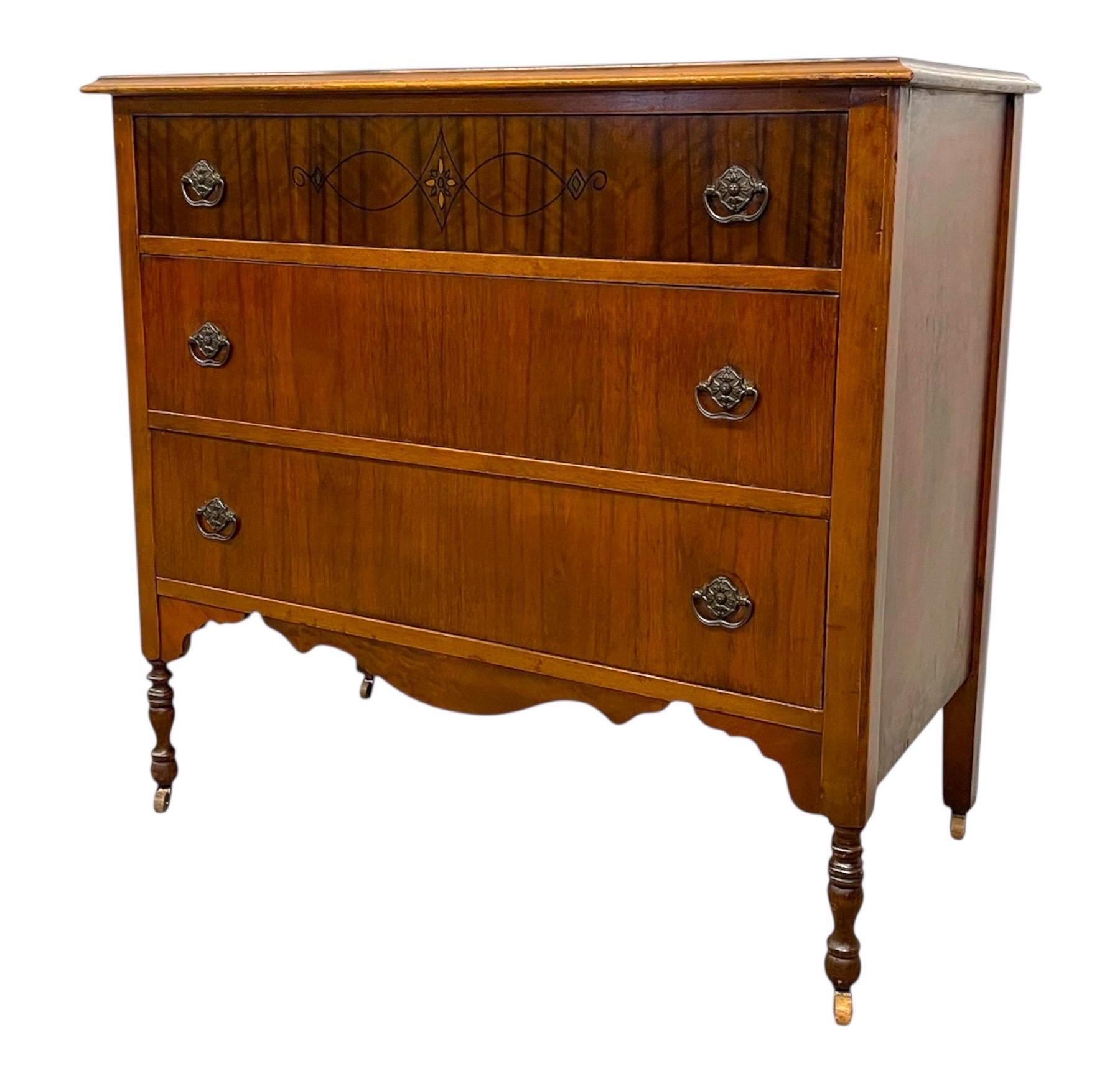 Diese wahrscheinlich antike Kommode, die von der John Furniture Company (gegründet 1891) gebaut wurde, ist ein Beispiel für die amerikanische Handwerkskunst des frühen 20. Jahrhunderts. Das Möbelstück ist aus nussbaumfarbenem Holz mit einer warmen,