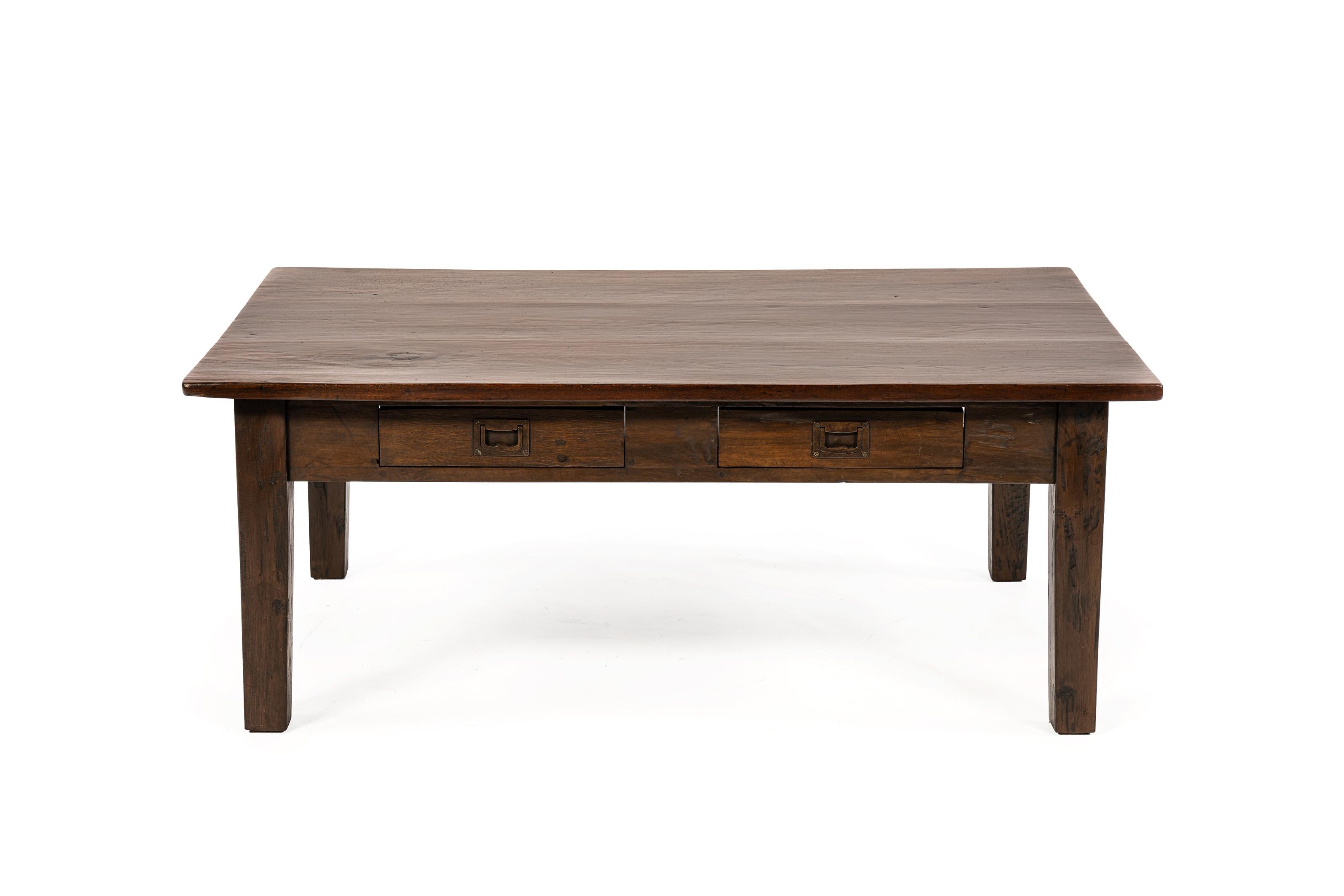 Se trata de una antigua mesa de centro de teca maciza, fabricada en las antiguas Indias Orientales Holandesas y que data de principios del siglo XX.
Su diseño refleja el estilo colonial holandés-indonesio, una mezcla de formalidad y proporción