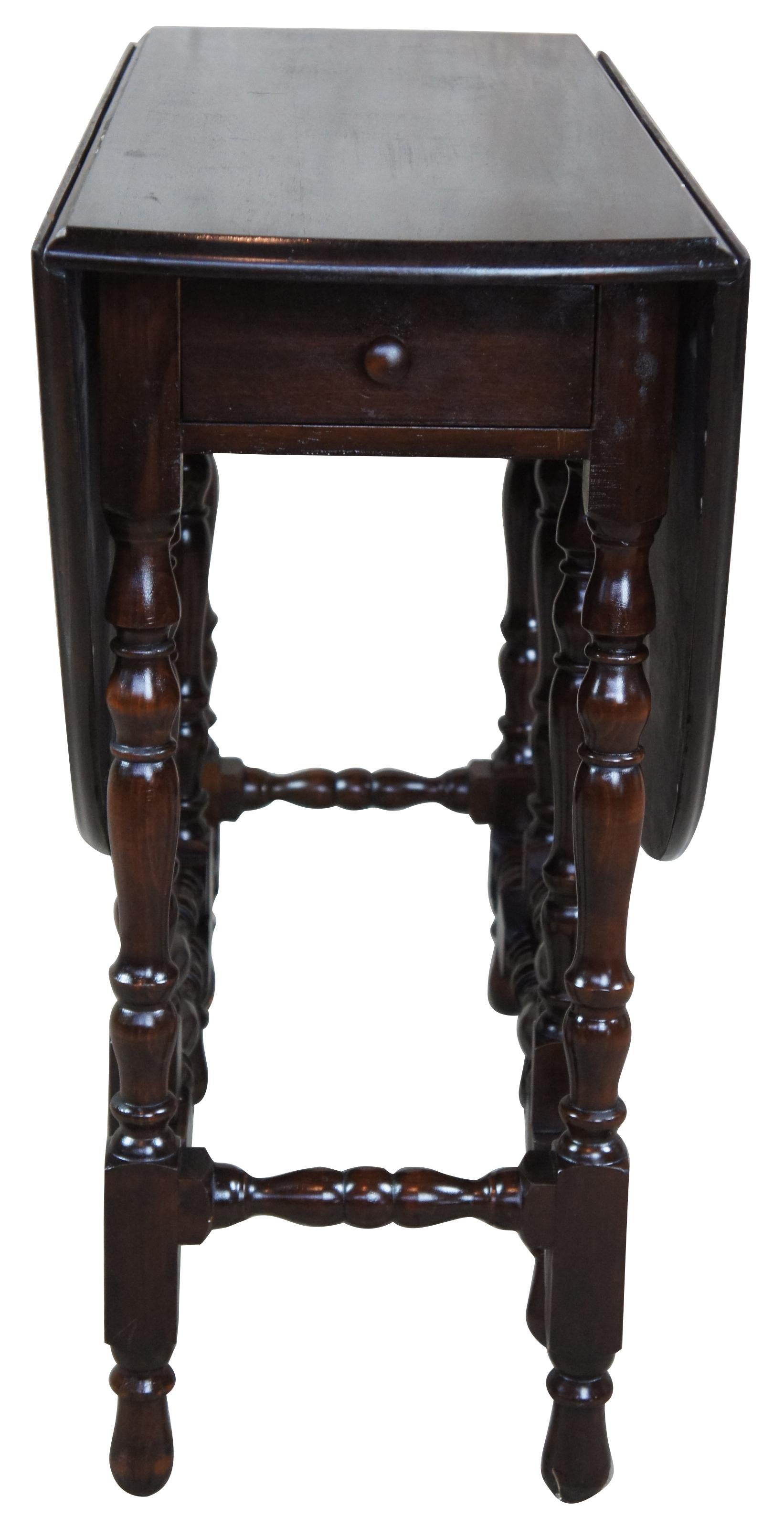 Early 20th century solid walnut drop leaf or gateleg table with drawer. Features turned supports in William & Mary style.
   