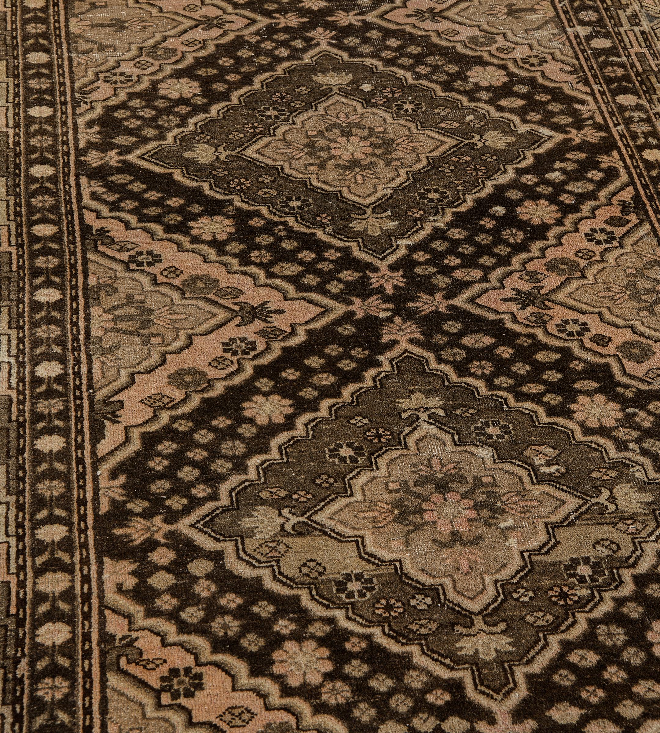 Este antiguo corredor de Khotan presenta un campo marrón con una columna de siete rombos enlazados, cada uno de los cuales contiene un rombo gris topo salpicado de motivos florales alrededor de un rombo cuspípedo central marrón topo con una cabeza