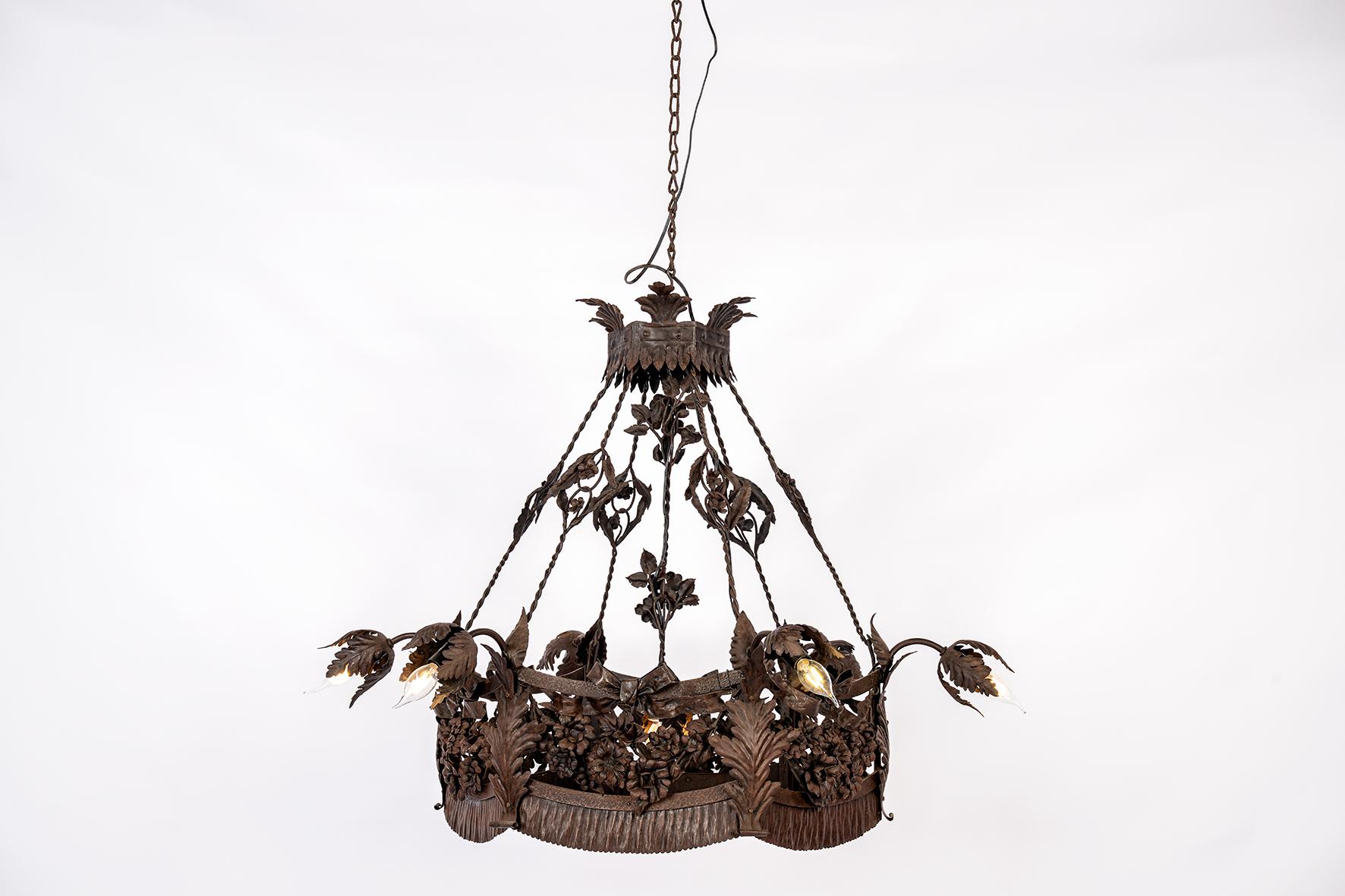 Aporta carácter atemporal, historia y artesanía a tu interior con esta extraordinaria lámpara de araña hecha a mano, en Francia alrededor de 1900-1910, durante el influyente movimiento Arts and Crafts.
Esta pieza única es una auténtica obra maestra