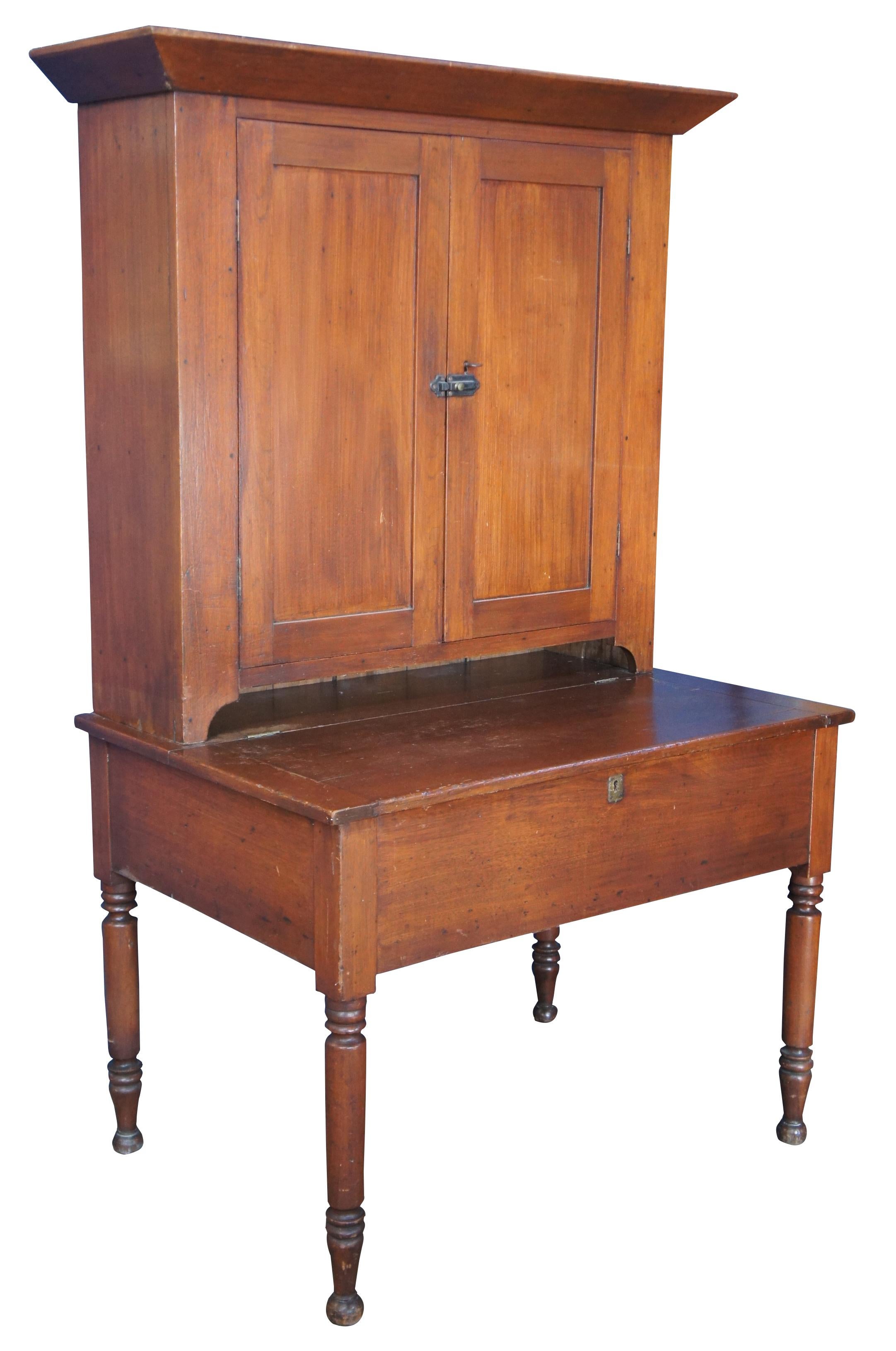 A beautiful plantation or secretary desk featuring primitive styling with upper cabinet or bookcase and lower flip top desk over turned legs. Made from poplar and walnut; first half 19th century.
 