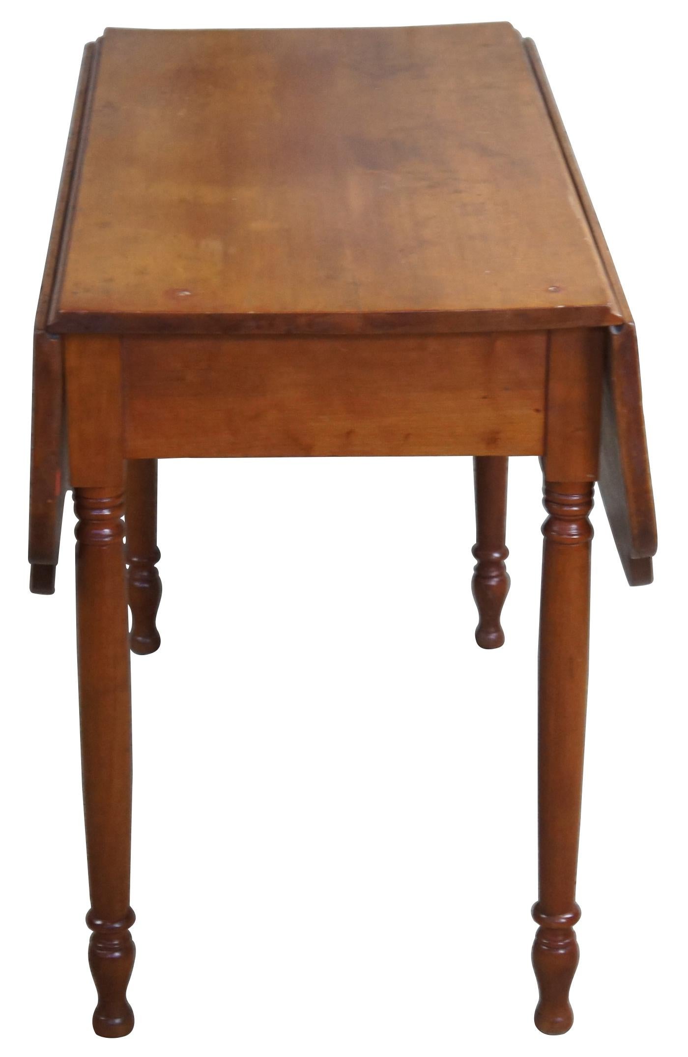 Late 19th century cherry drop-leaf table. Features a uniquely shaped top over turned legs leading to bun feet. 

Leaves add 12.5