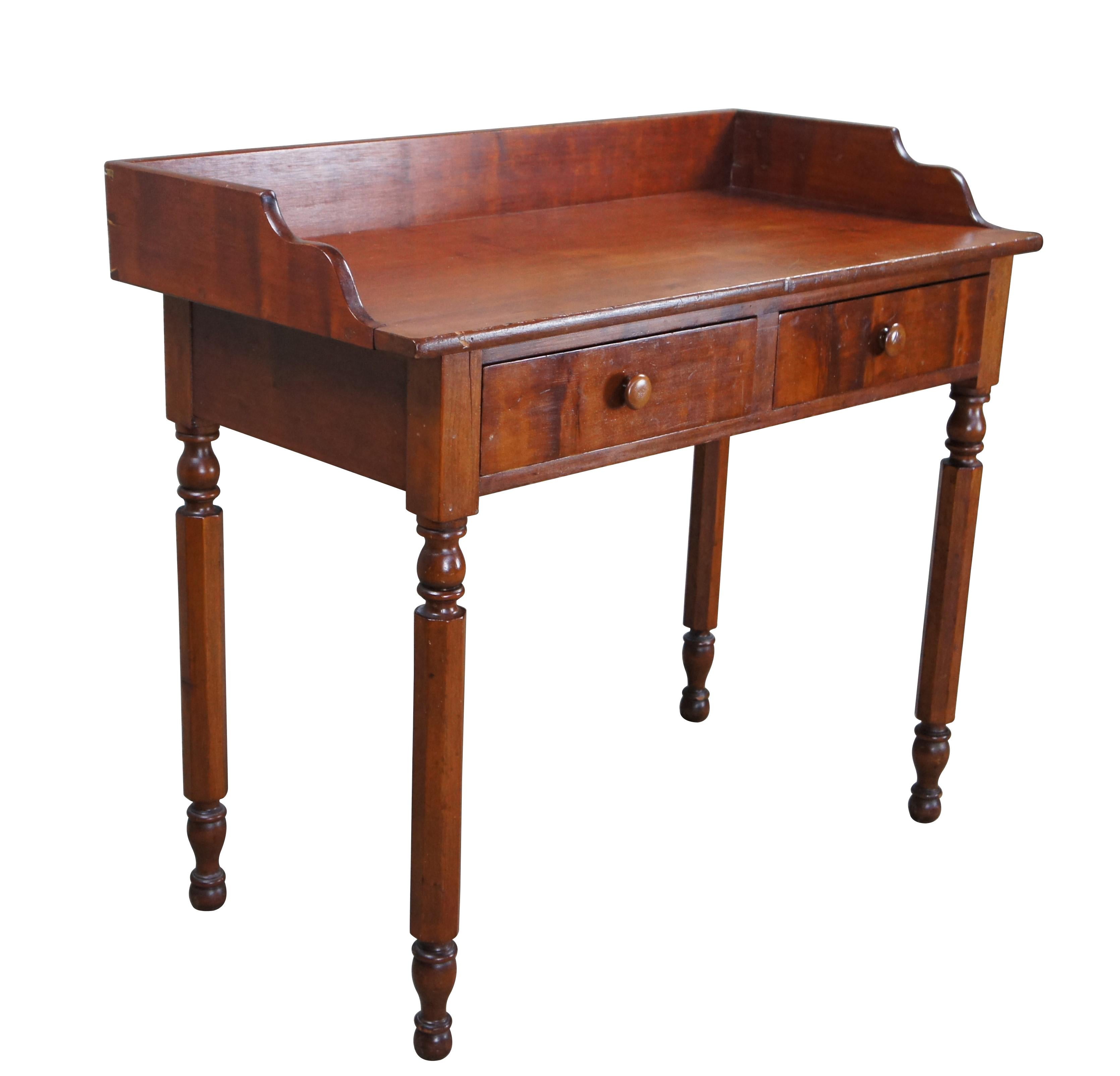 Antique Early American Sheraton / Regency period farmhouse washstand / writing desk / or console table.  Made of cherry featuring tall gallery backsplash with serpentine accents over two drawers and turned legs.  

Dimensions:
38