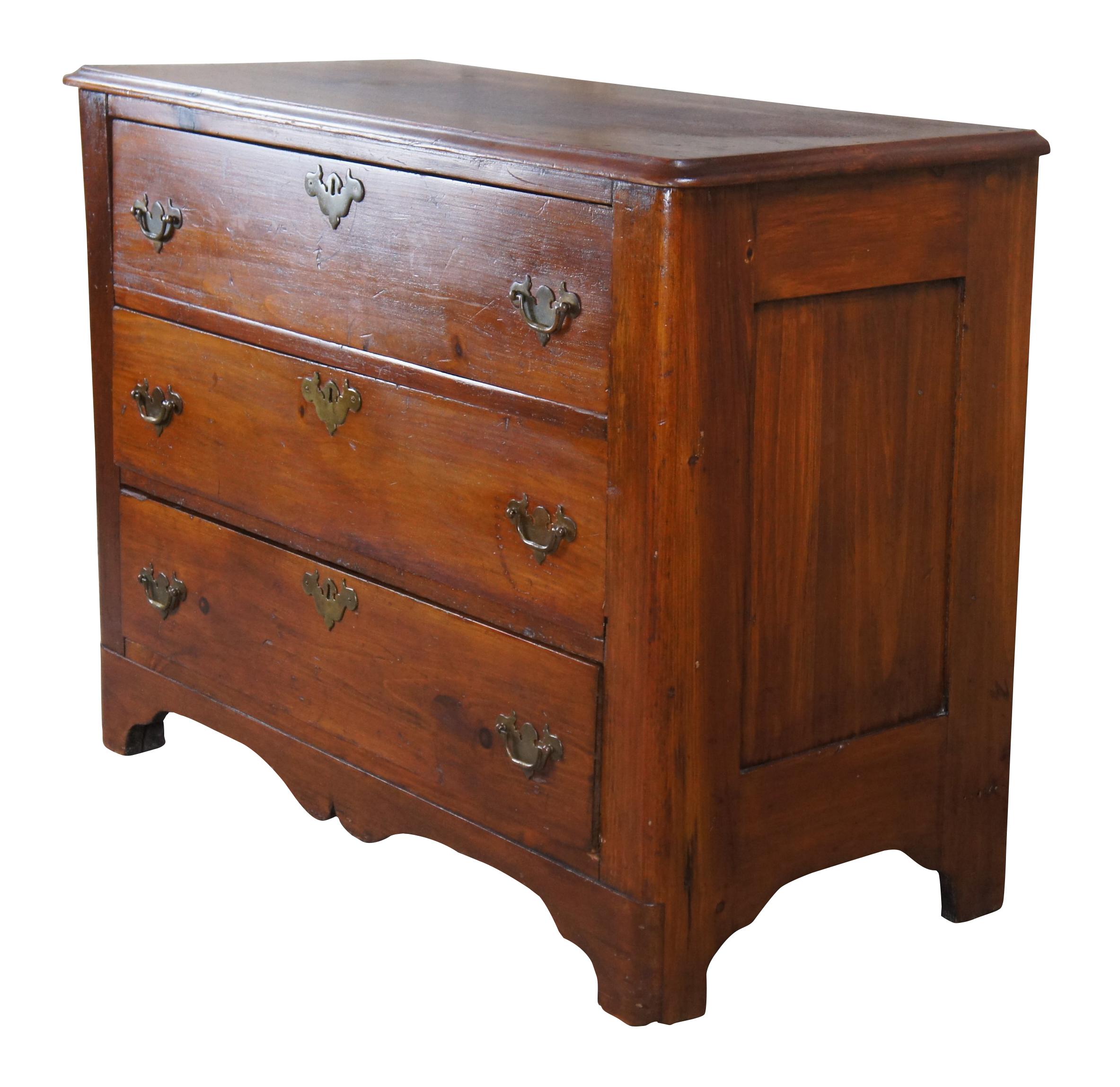 Antique Early American style chest of drawers or dresser, circa 1900s. Made of pine featuring three drawers with colonial brass bat wing hardware and serpentine apron.