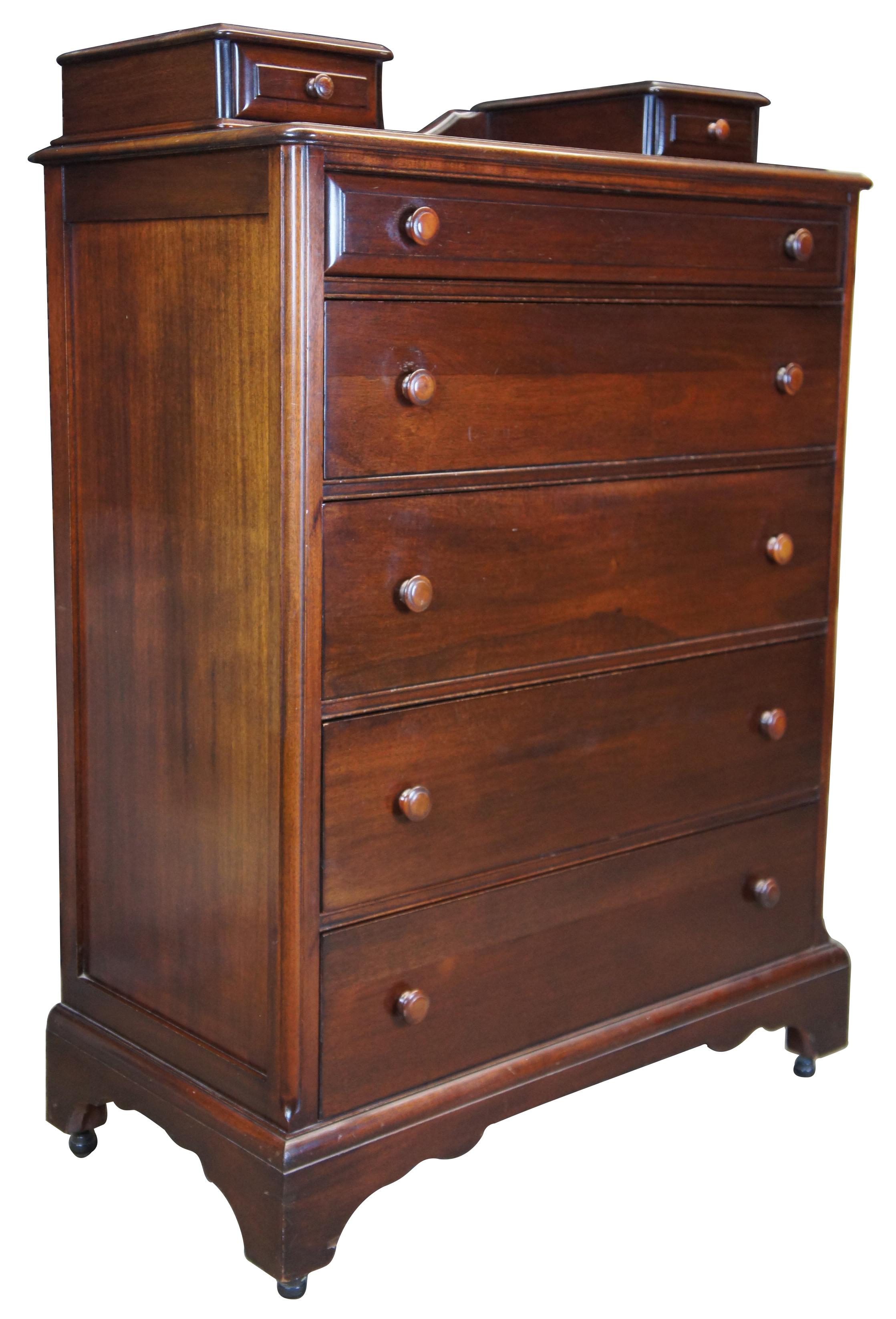 Tallboy dresser, circa 1940s. Made from mahogany in early American styling with six drawers in addition to two upper glove box drawers. Features castors for ease of movement.
  
