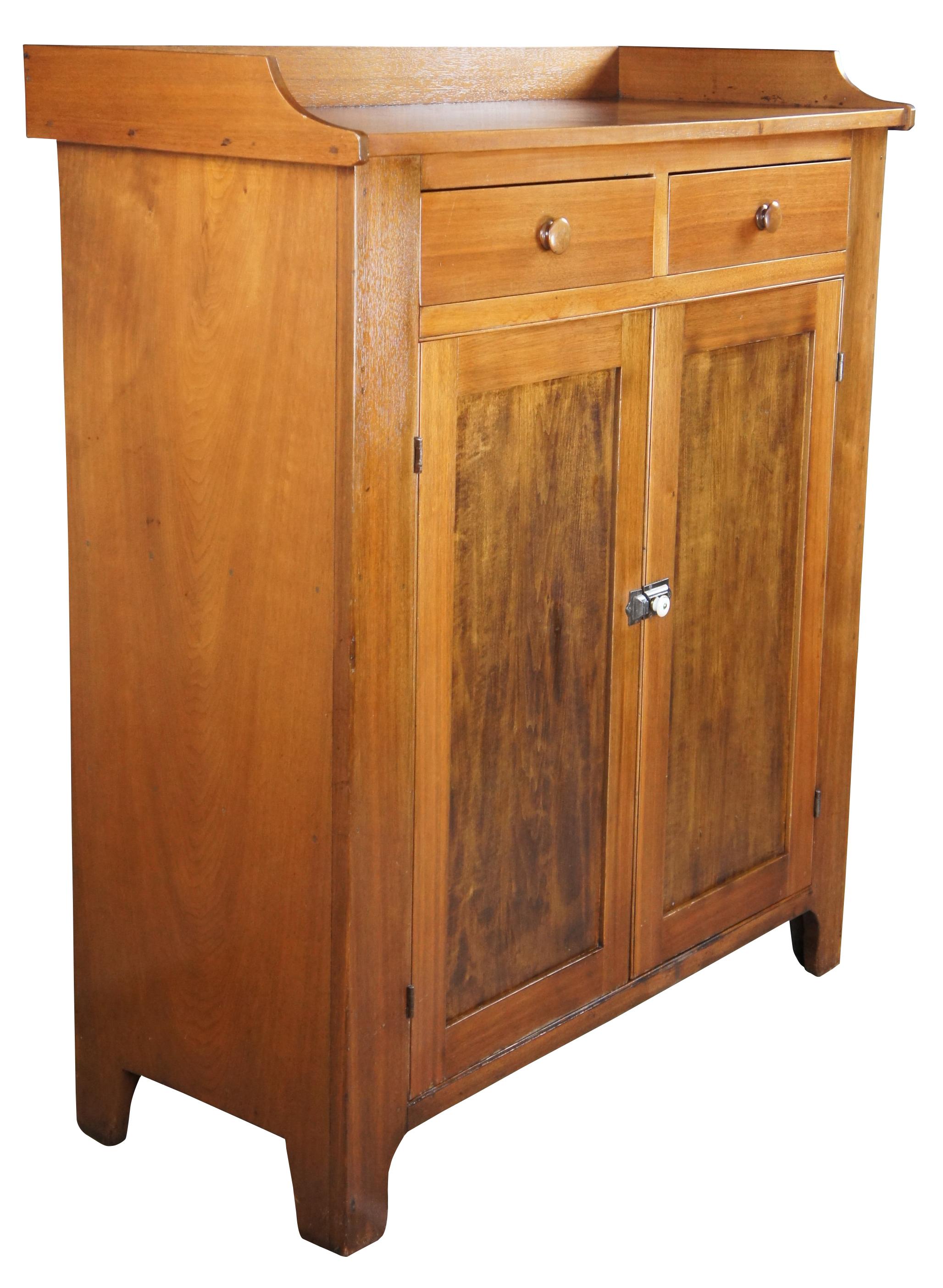 A warming handmade mid-19th century early American jelly cabinet or pantry cupboard. A rectangular form made from American Walnut with an upper surface enclosed by a backsplash over two hand dovetailed drawers and lower cupboard with two shelves.