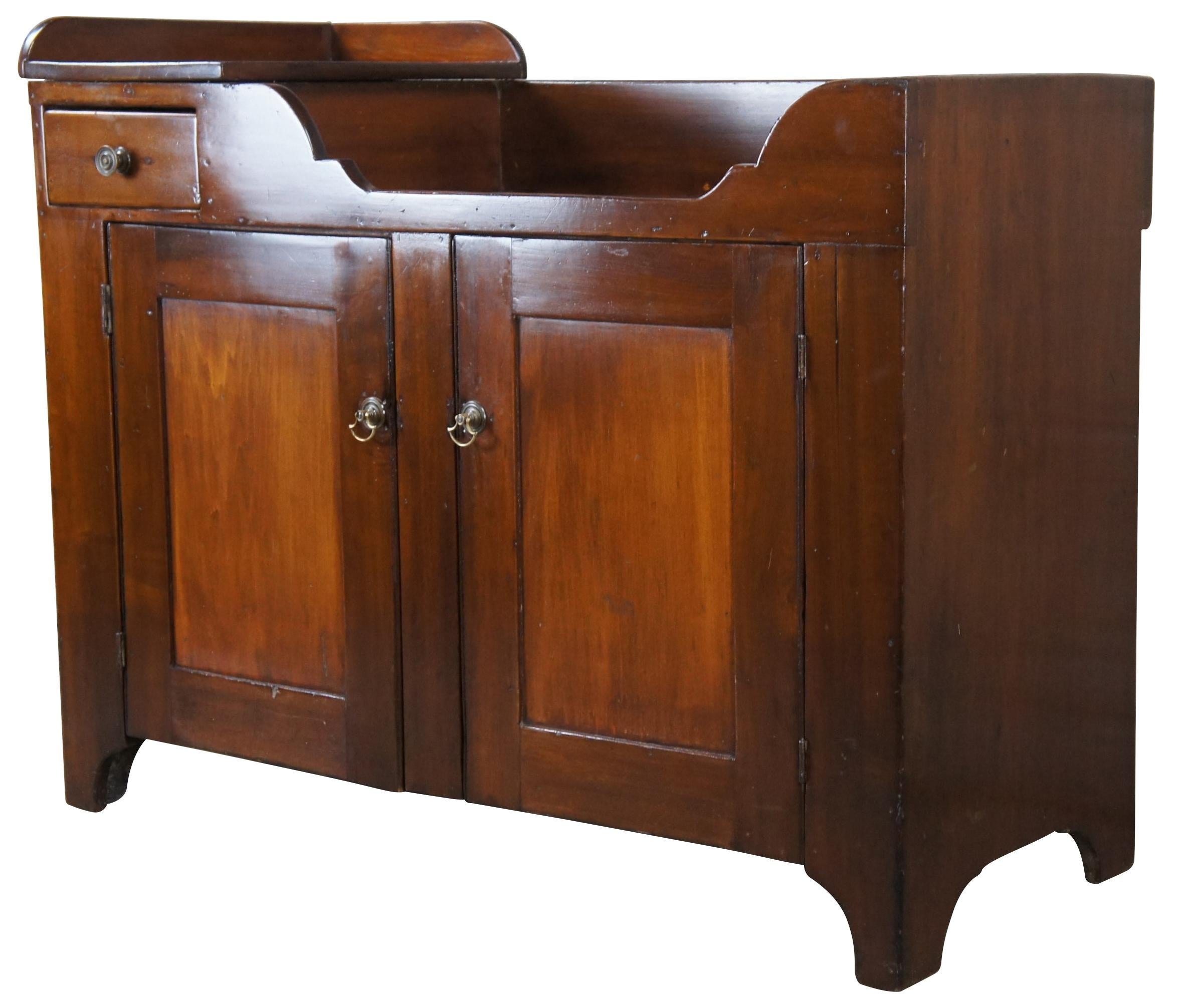 Antique Early American farmhouse dry sink or washstand cabinet. Made of walnut featuring two tiered upper surface with one drawer and two doors that open to lower shelves.

Measures: 42.25