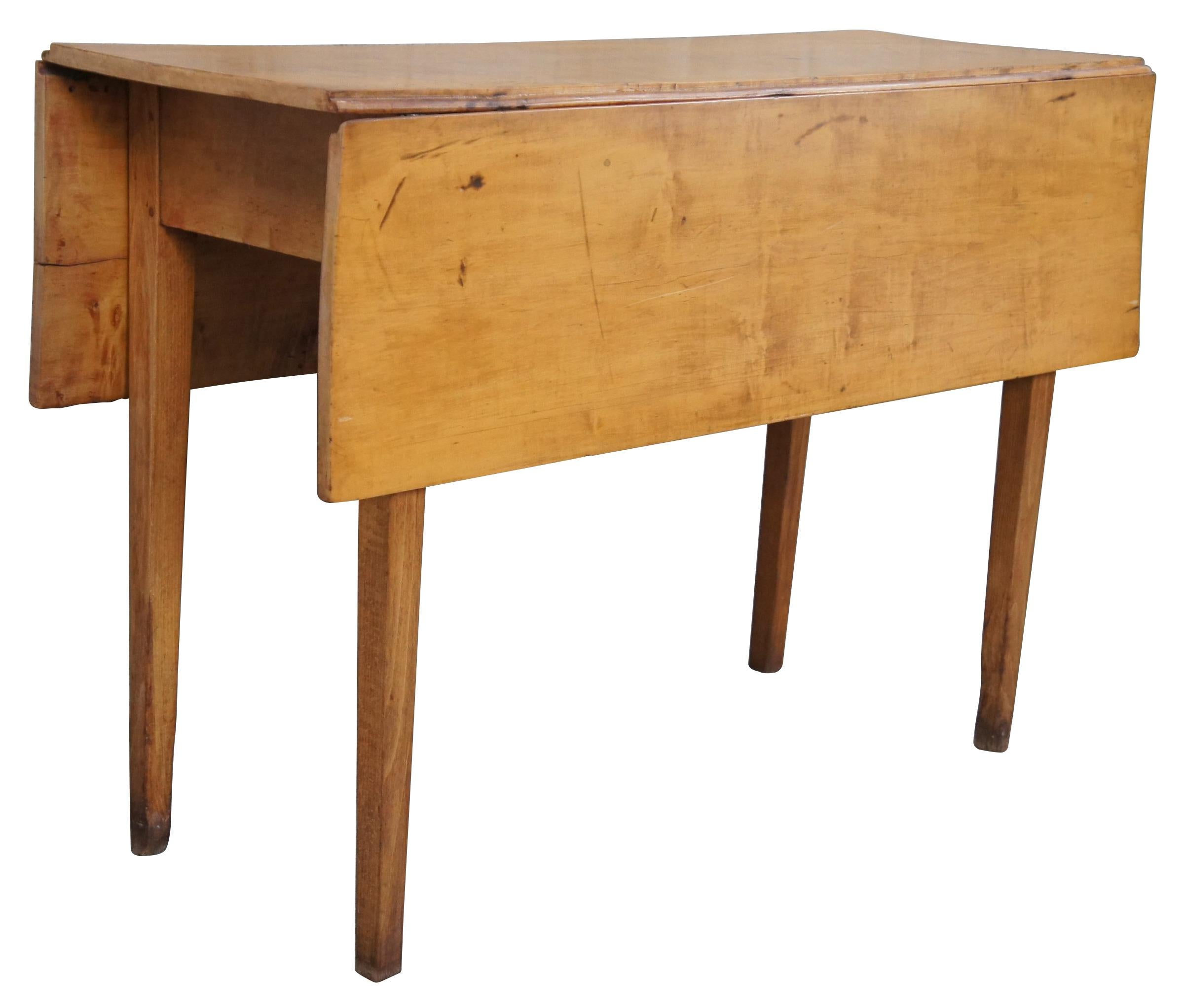 An antique 19th century tulipwood drop leaf table. Great for use as a breakfast or console table. Features a rectangular form supported by square tapered legs. Measure: 42