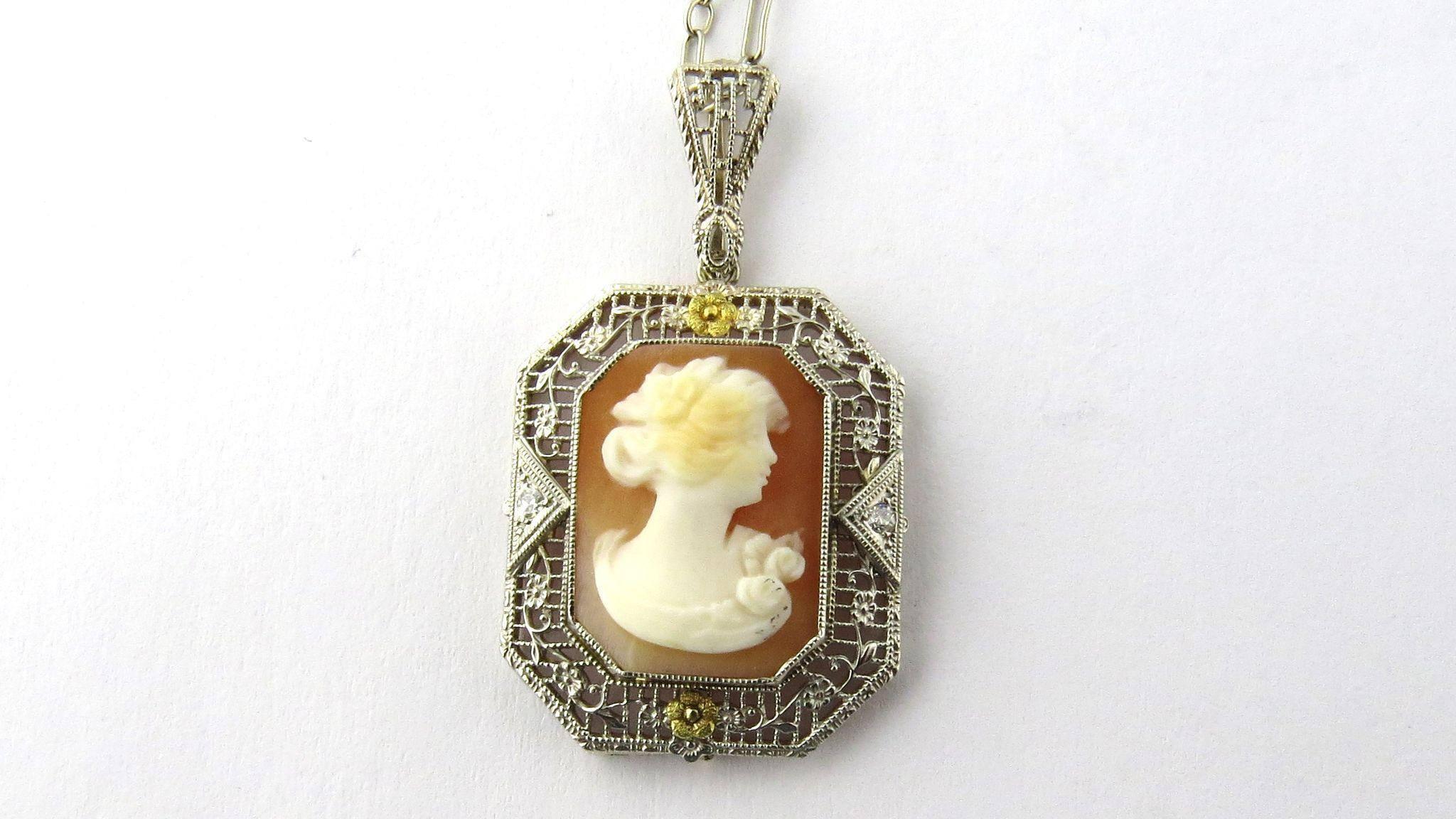 Delicate 14K white gold filigree cameo pendant with 14K yellow gold flower accents at top and bottom 

Cameo is adorned on each side with a diamond. Single cut at .03ct each. Color H-I Clarity SI(1). 

Marked: 14K on bale. Weighs 5.3 g, 3.45 dwt.