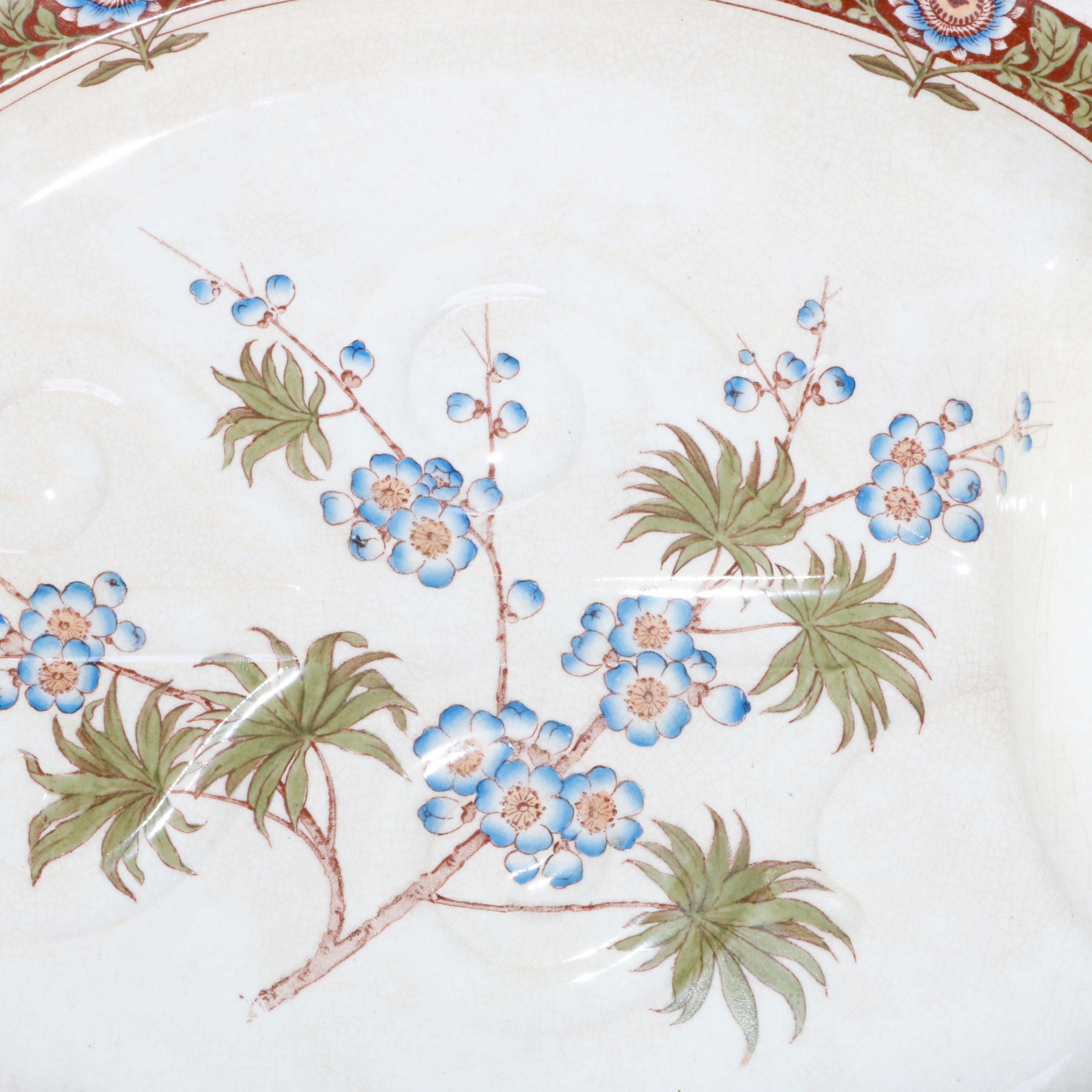 An antique and early English aesthetic carving platter offers porcelain construction with deeper well having hand painted Japanese foliate design and rim with repeating reserves, platter elevated on three feet, hand scribed on base as photographed,