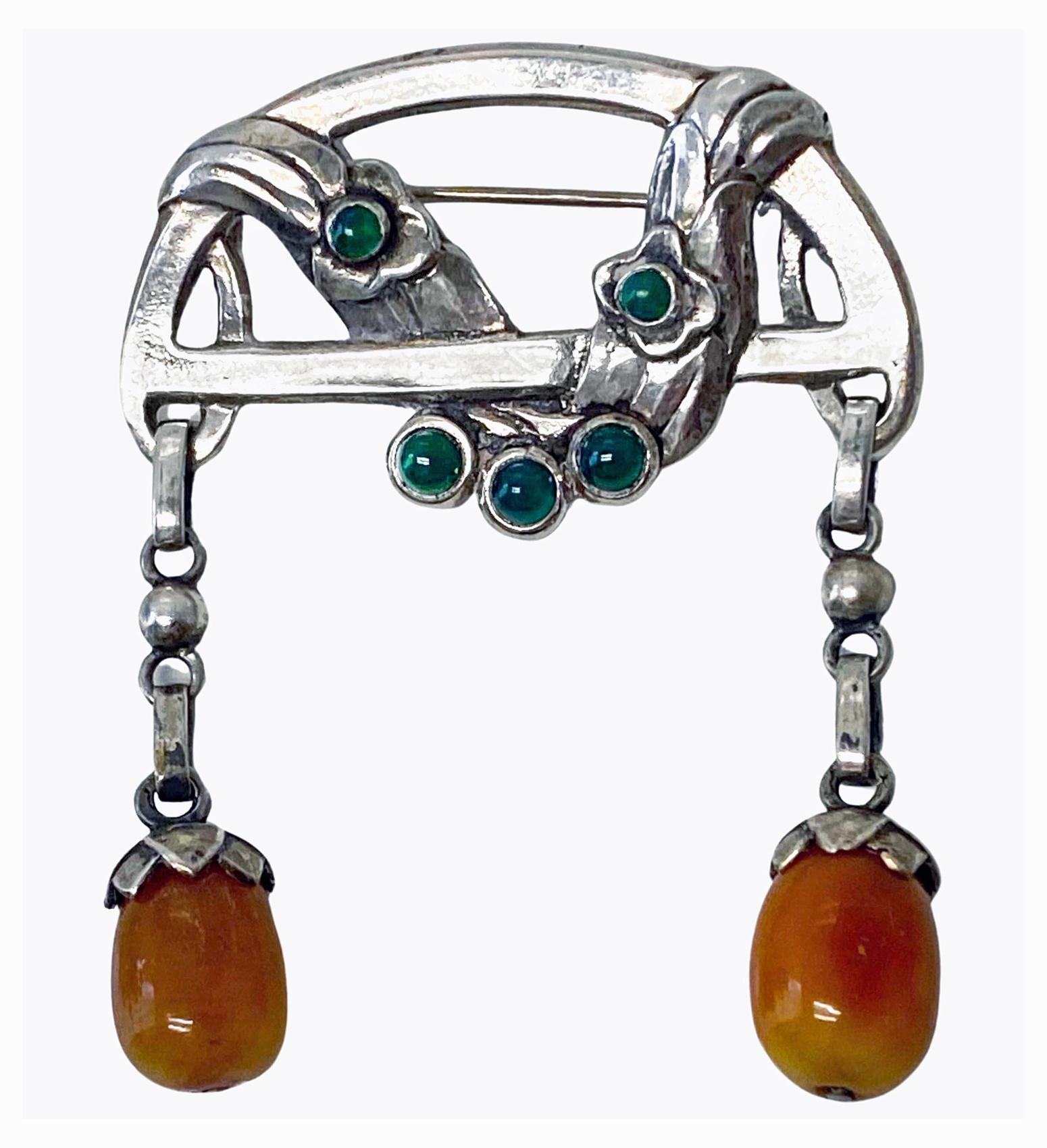 Antique early Georg Jensen brooch C.1909 design #8. The drop brooch with cabochon set green agates and two amber drops, twist foliate design. The reverse with Georg Jensen 828 S Gi 8. Marks for 1909 -1914. Measures 1 7/8