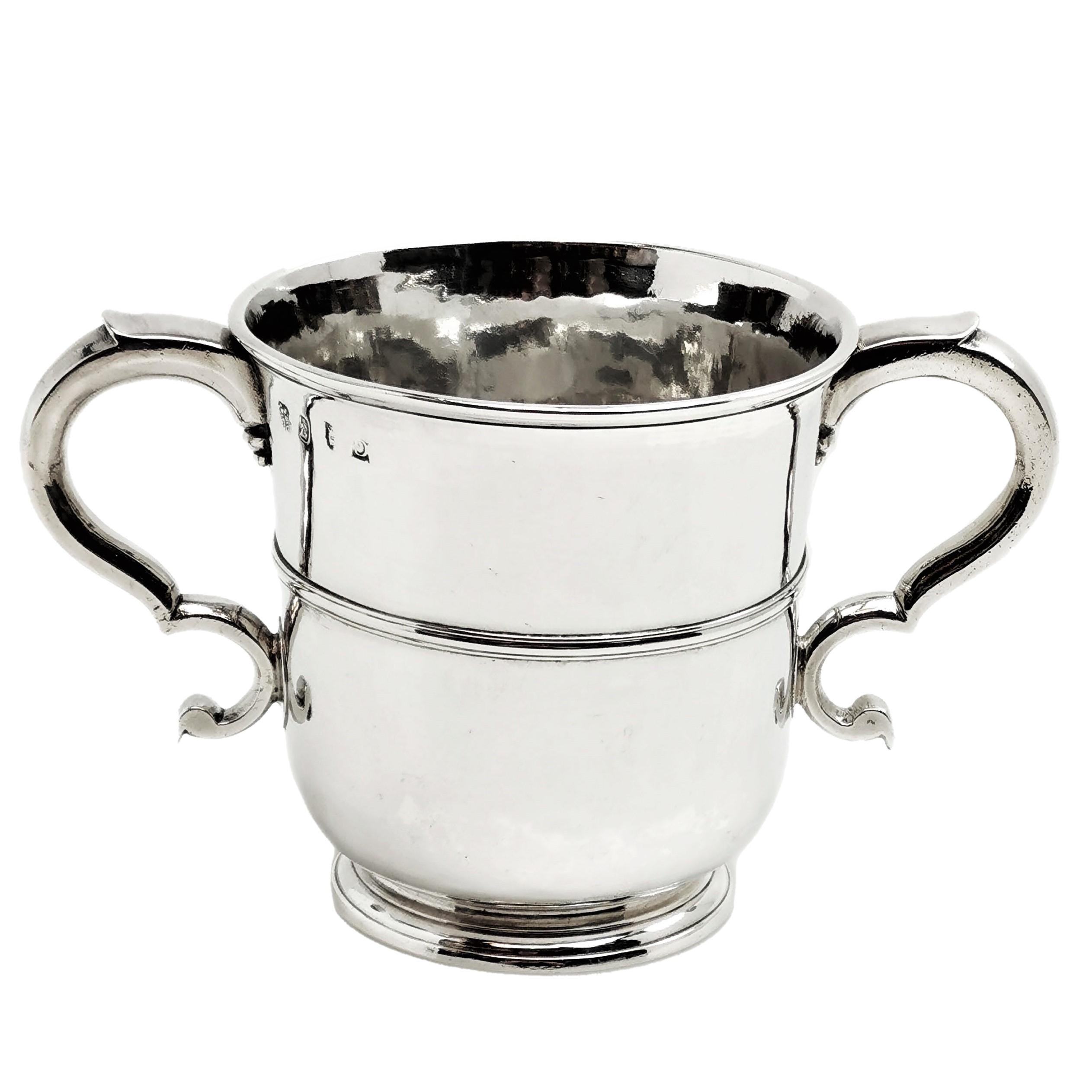 A lovely Antique George I solid Silver Cup with two elegant scroll handle. The elegant two-handled Cup stands on a low spread foot and has a band around the centre. It is unembellished except for the AA engraved initials.
 
 Made in London in 1722