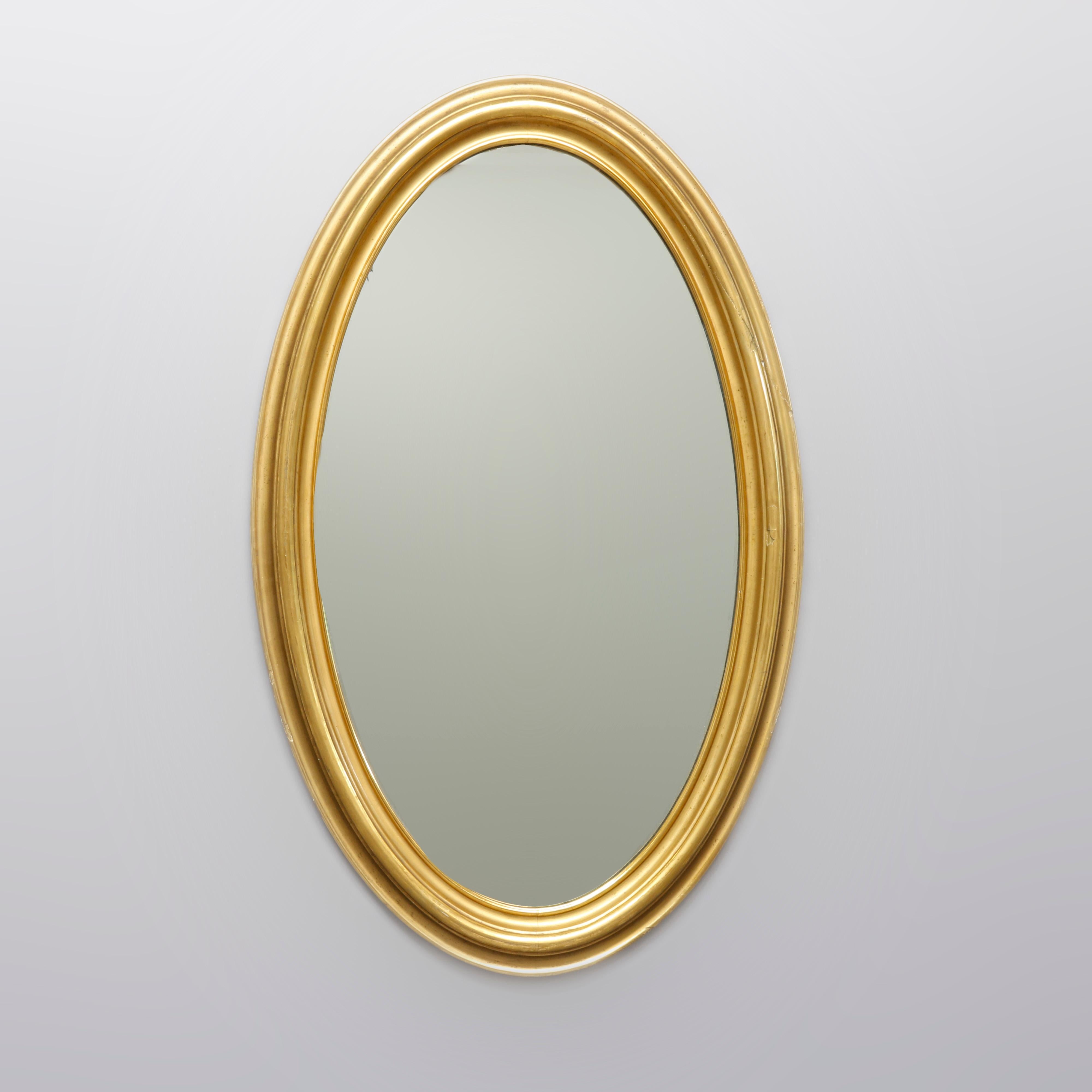 An early antique wall mirror features large giltwood oval frame, circa 1830.

Measures: 41.66
