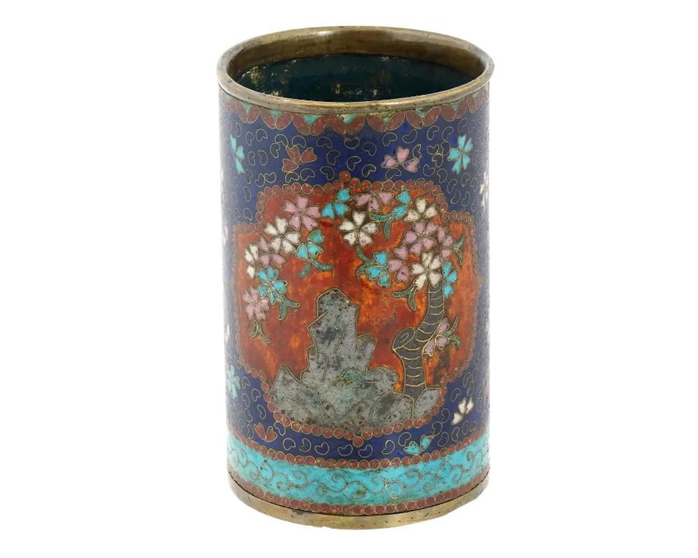 An antique Japanese copper brush pot with cloisonne enamel design. Early Meiji period, after 1868. Cylinder shape. Cherry blossom motif and floral patterns in cobalt and turquoise blue, red, pink, and white. Presumably a work of Namikawa Yasuyuki,