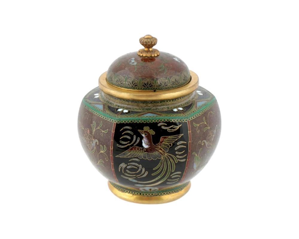 Jarre japonaise ancienne, du début de l'ère Meiji, recouverte d'émail et de cuivre doré. L'extérieur de la jarre est orné de médaillons en émail polychrome représentant des oiseaux Phoenix et des fleurs, réalisés selon la technique du cloisonné. Le