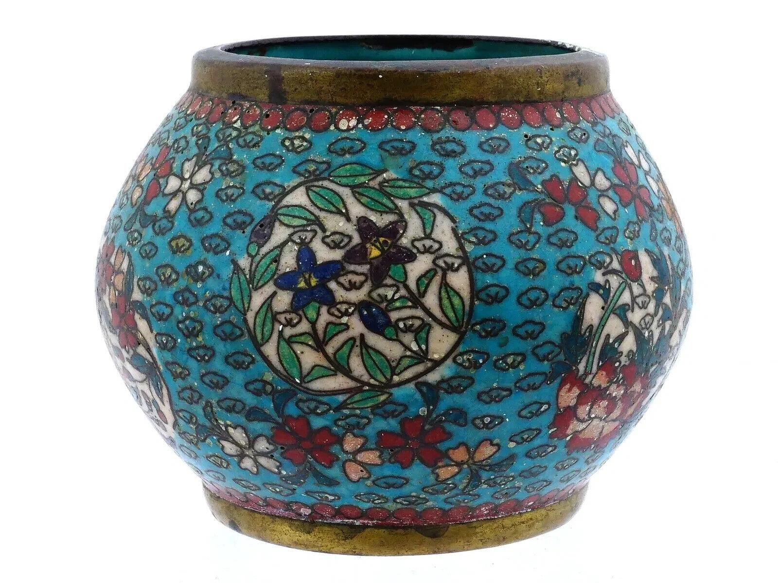 Ein antiker japanischer Pinseltopf aus der Meiji-Ära mit Emaille und Messing. Die Oberfläche der runden Schale ist mit einer polychromen Darstellung von blühenden Blumen auf weißem und blauem Grund emailliert, umgeben von floralen Motiven.  Muster,