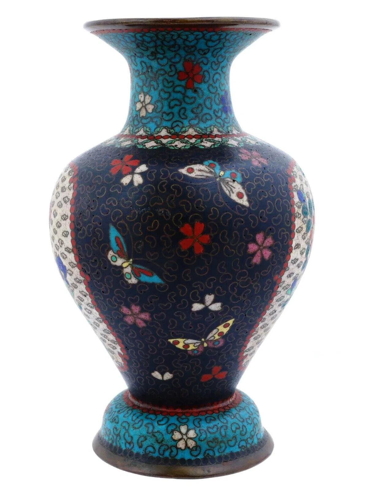 Eine antike japanische Cloisonné-Emaille-Vase aus der Meiji-Periode mit Blumenmotiven und Schmetterlingen auf weißem und dunkelblauem Grund - ein feines und sammelwürdiges Stück japanischer Kunstfertigkeit. Die Einbeziehung von Blumenmotiven und