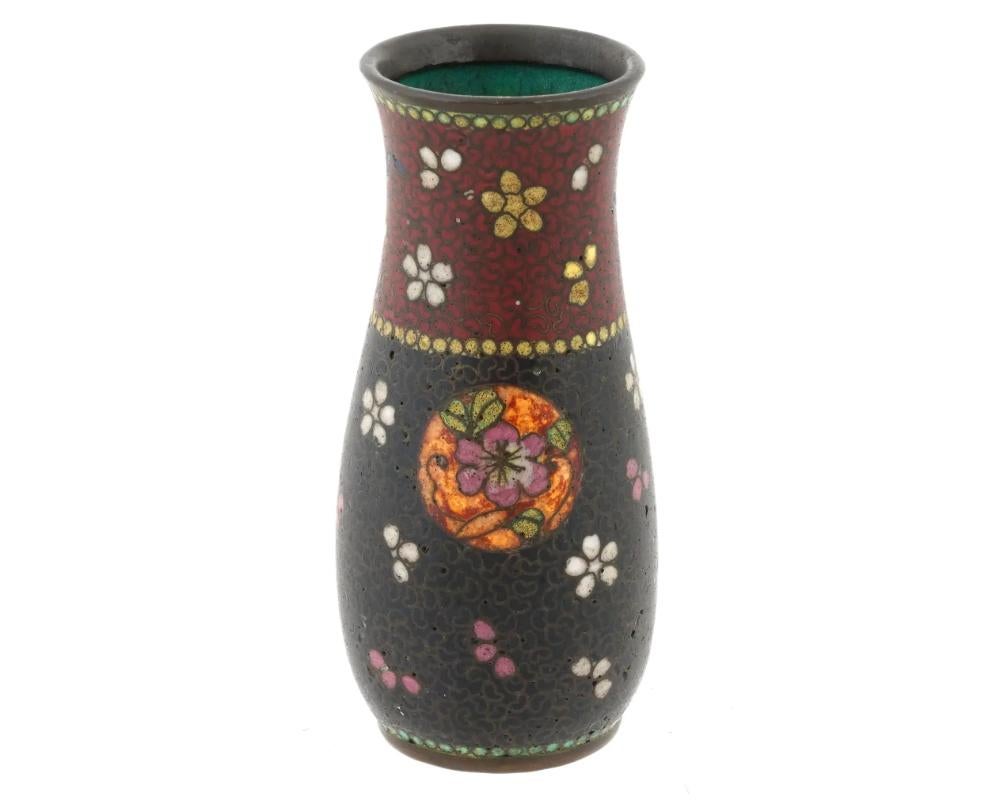 Antico vaso rosso floreale traslucido in smalto cloisonne giapponese dei primi anni Meiji

Un antico vaso giapponese in rame con smalto cloisonne policromo. Primo periodo Meiji, circa 1870. Forma cilindrica leggermente curva. Ornamenti floreali su