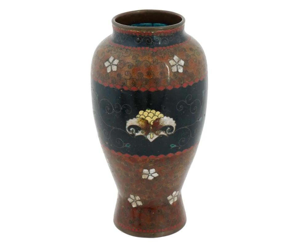 An antique Japanese early Meiji period cloisonne vase, attributed to the master artisan Namikawa Yasuyuki. The meticulous application of the cloisonné technique in depicting vibrant floral patterns showcases the artistry and skill of early Meiji