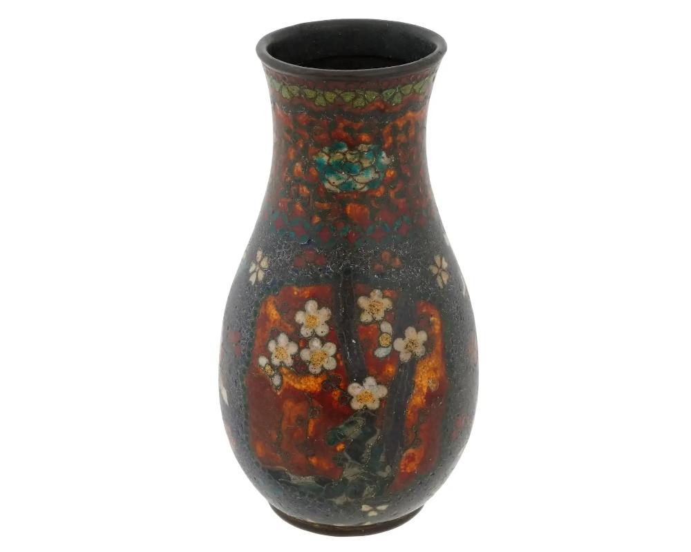 An antique Japanese early Meiji period cloisonne vase, attributed to the master artisan Namikawa Yasuyuki. The precisely detailed floral scenes, set within the delicate beadwork, create a visual spectacle, showcasing vibrant colors and meticulous