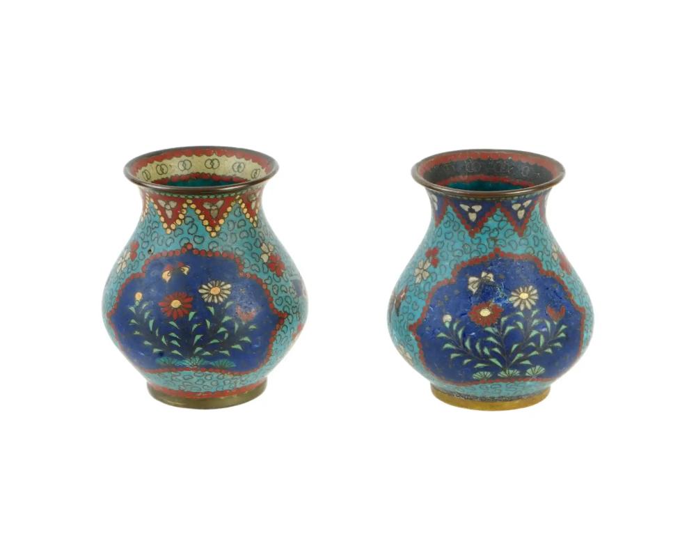 A pair of antique Japanese vases from the early Meiji period. Two vases represent Day and Night and are decorated with polychrome enamel using the cloisonne technique. Two vases that make up a set have the same design but slight differences in