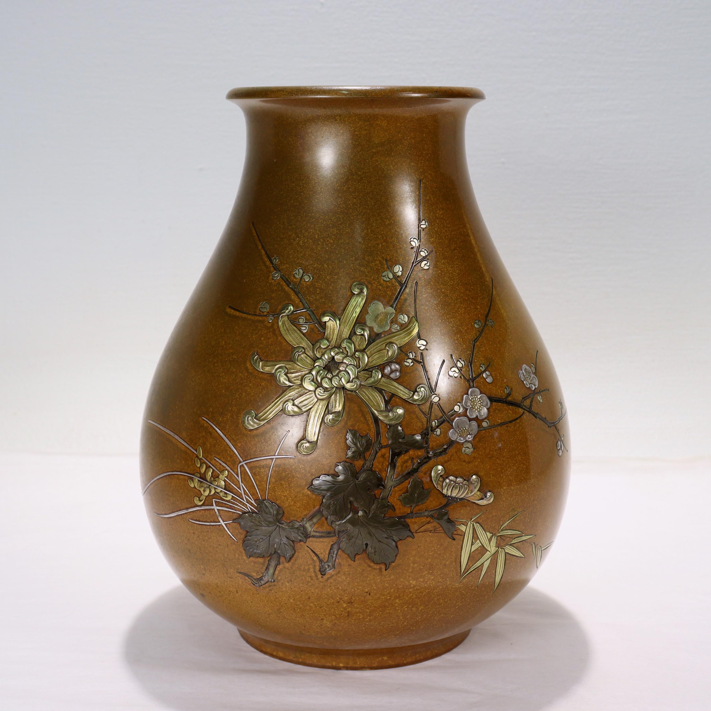 A fine vintage Japanese mixed metals vase.

Decorated throughout with intricate branches and flowers in gold and silver against a 'yellow bronze' ground.

Signed ??? (Made by Houn) on the side, and with a full dedication inscribed to the base.