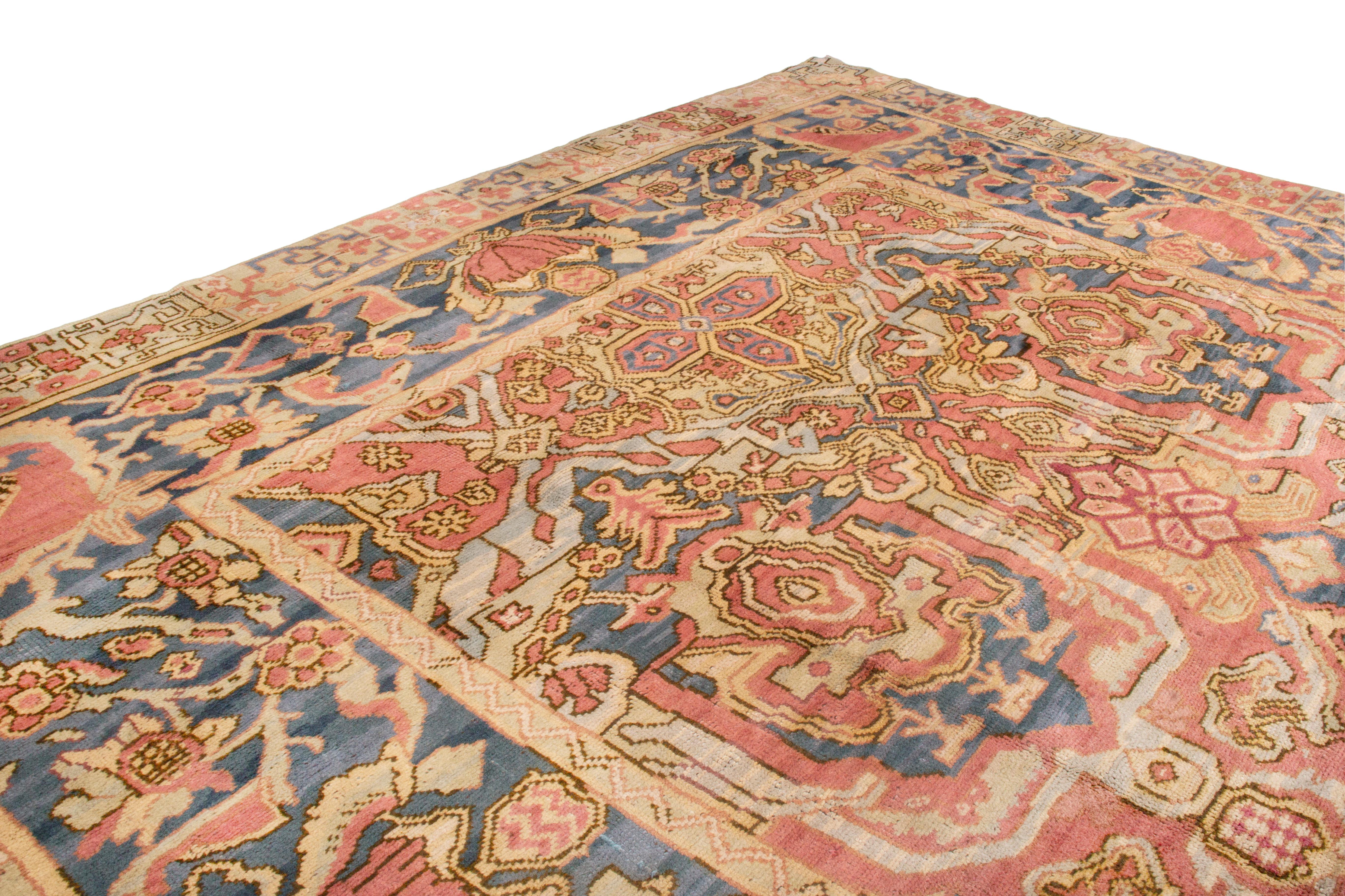 This antique arts & crafts wool rug is an early Spanish piece from 1900, featuring an all-over floral design with lighter pastel red, royal blue and tan gold dye in large scale and pristine condition. Complementing the intricate kaleidoscopic