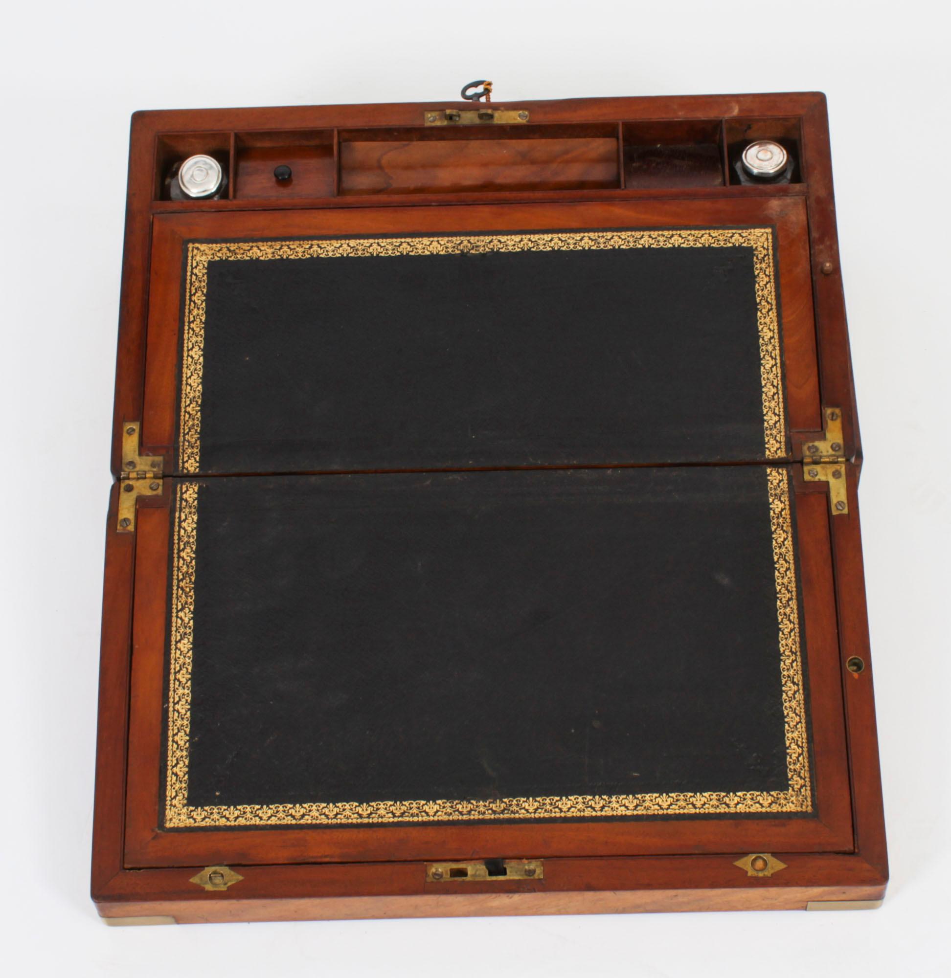 A elegant Campaign writing slope with brass bound corners and blank cartouche to the top, circa 1840 in date
 
The beautifully polished flame mahogany case has a wonderful age-related patina and a key lockable top. Inside, there is a lift-up gold