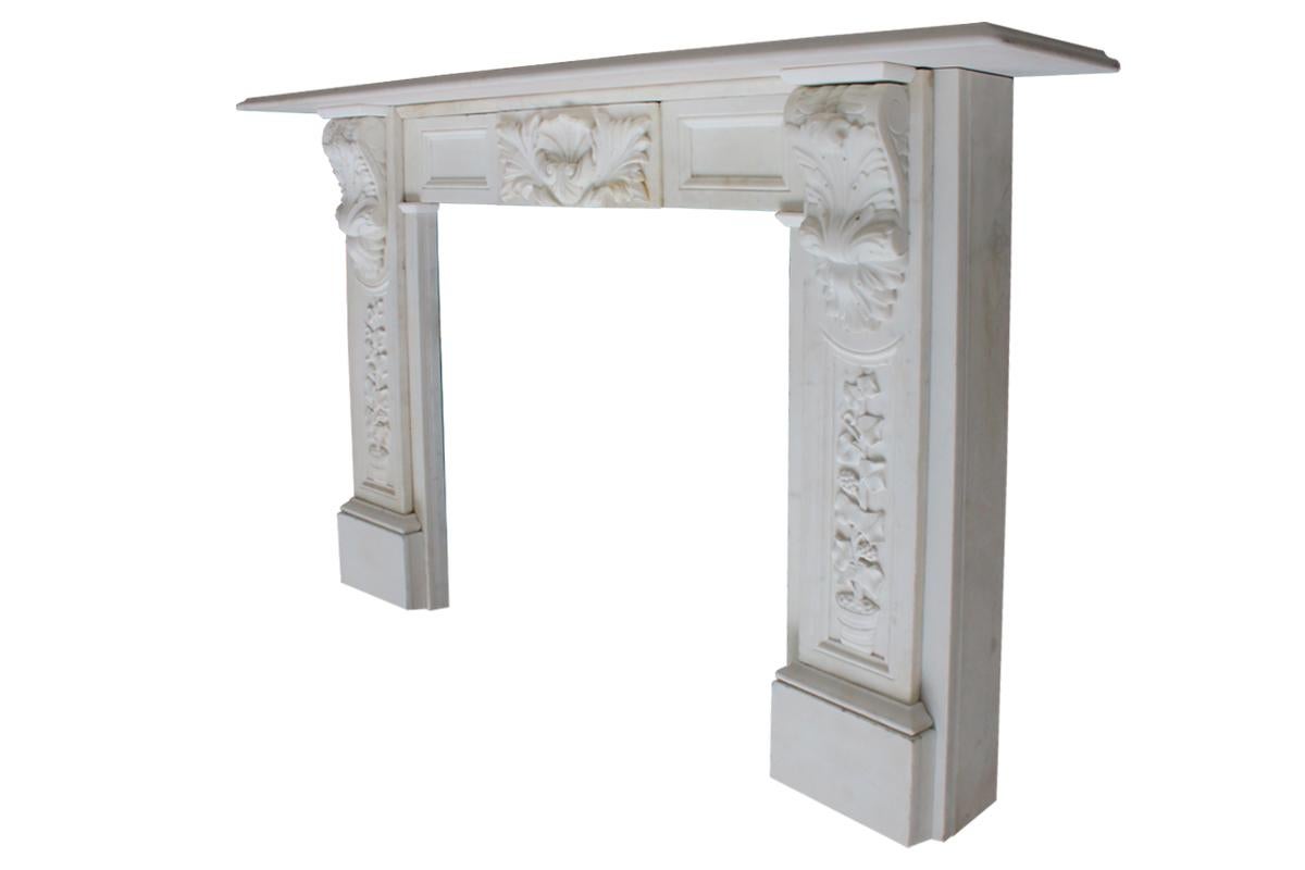 Antique early Victorian statuary marble fireplace surround with corbels carved with scrolling acanthus leaves supporting the shelf. Further acanthus leaves carved in high relief to the central tablet in the frieze flanked by fielded panels. To the