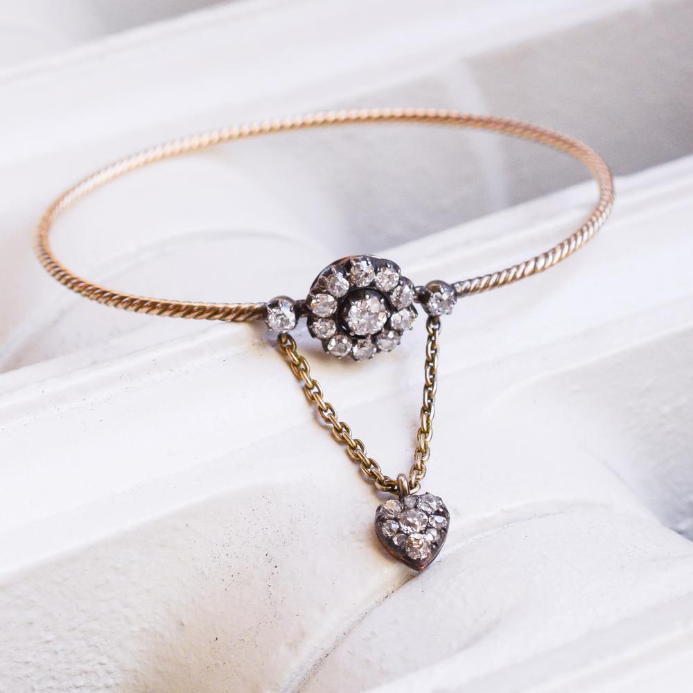 A blossom of old mine diamonds perches on your wrist as a Diamond heart reaches your hand. This romantic bangle was created c. 1840, and carries it’s original charm to us today, 179 years later. It is 15 Kt. gold, the English standard. The total old