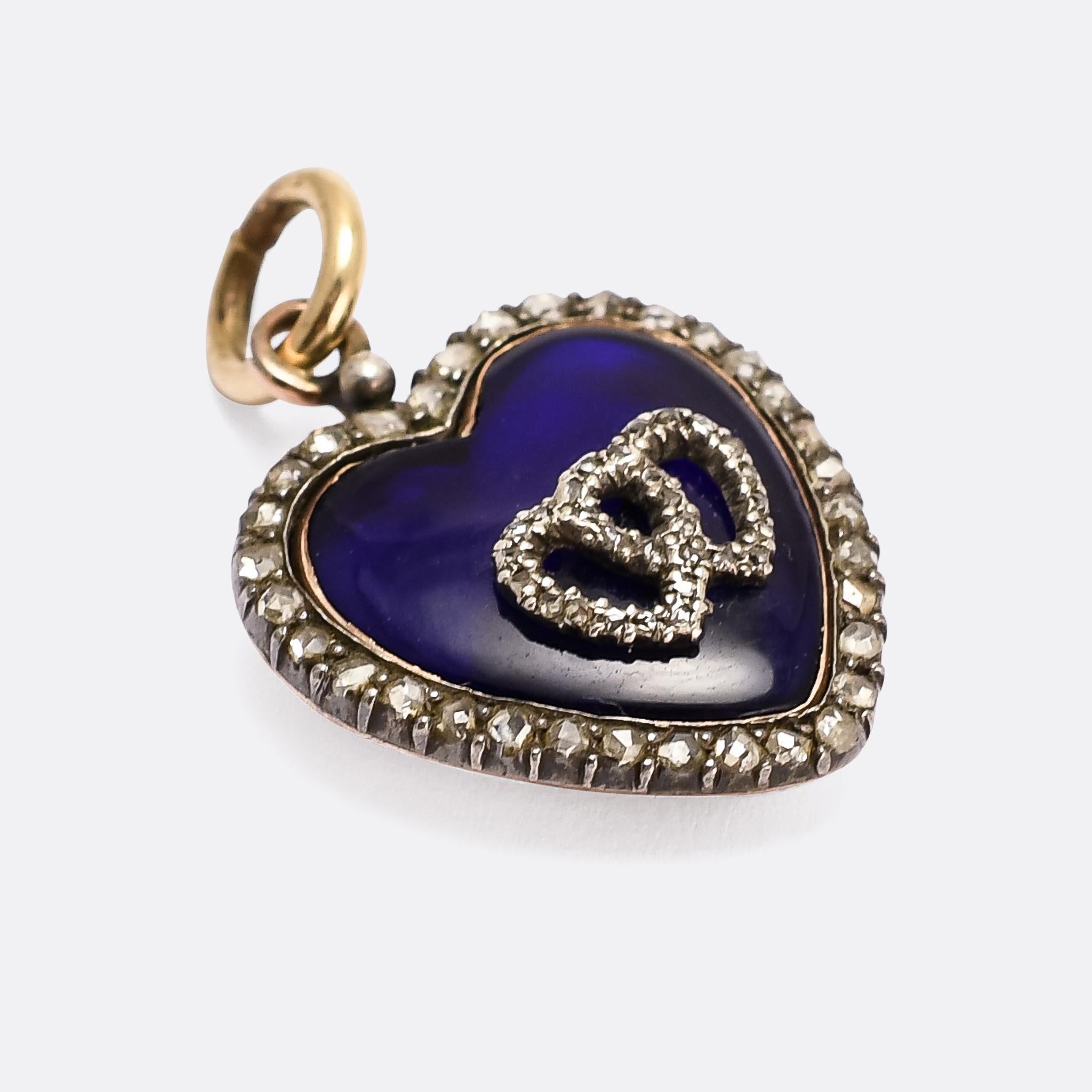 A sublime early Victorian heart pendant finished in vitreous blue enamel and emblazoned with an interlocked double heart motif. It was made around 1840, with rose cut diamonds set into the border as well as the double heart. Crafted in 15 karat gold