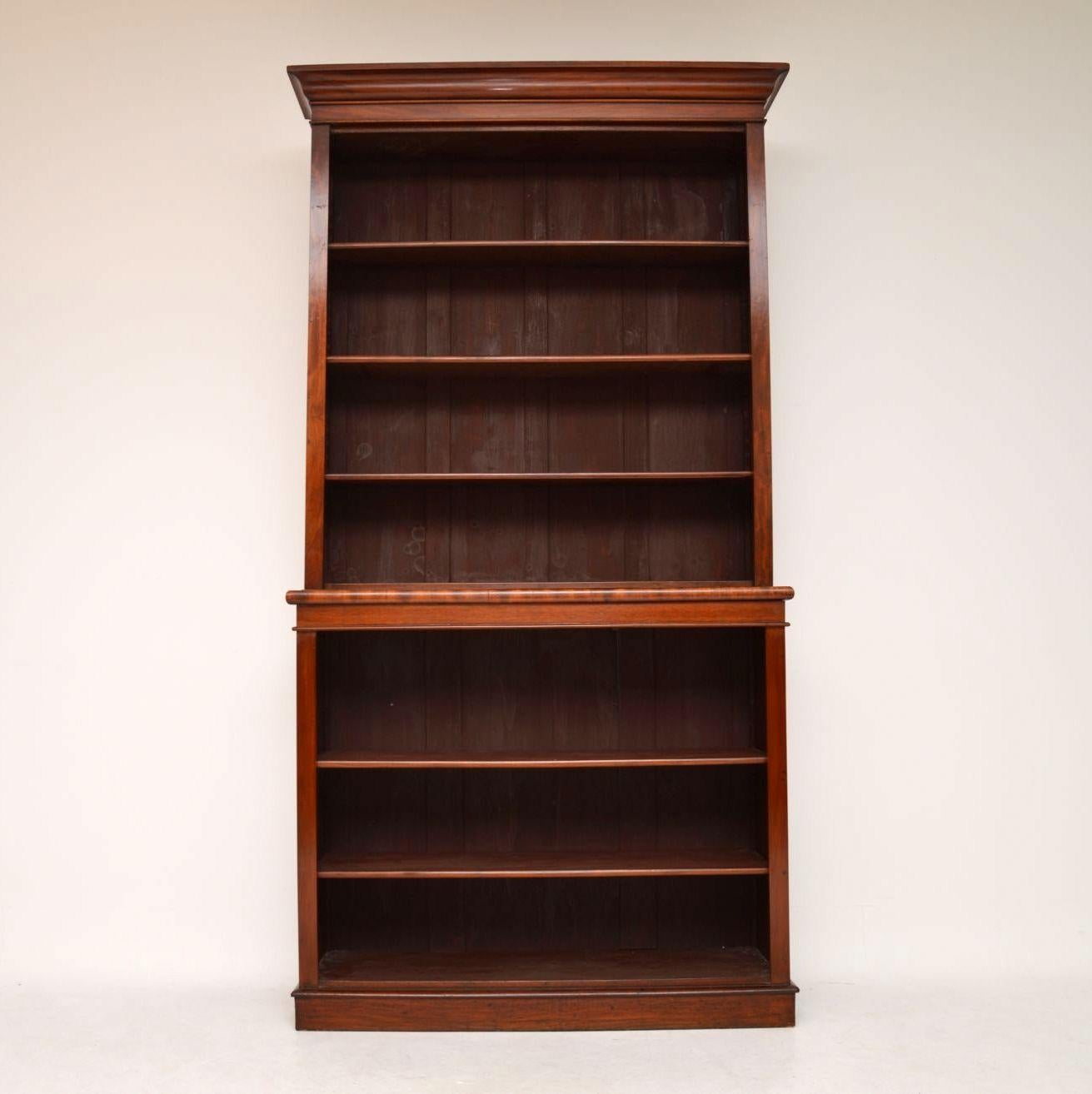 Large antique Victorian mahogany two section open bookcase in excellent condition adn full of character. The shelves, which are mahogany faced, are all adjustable top and bottom on sharks teeth supports. The back is panelled. It has a top cornice