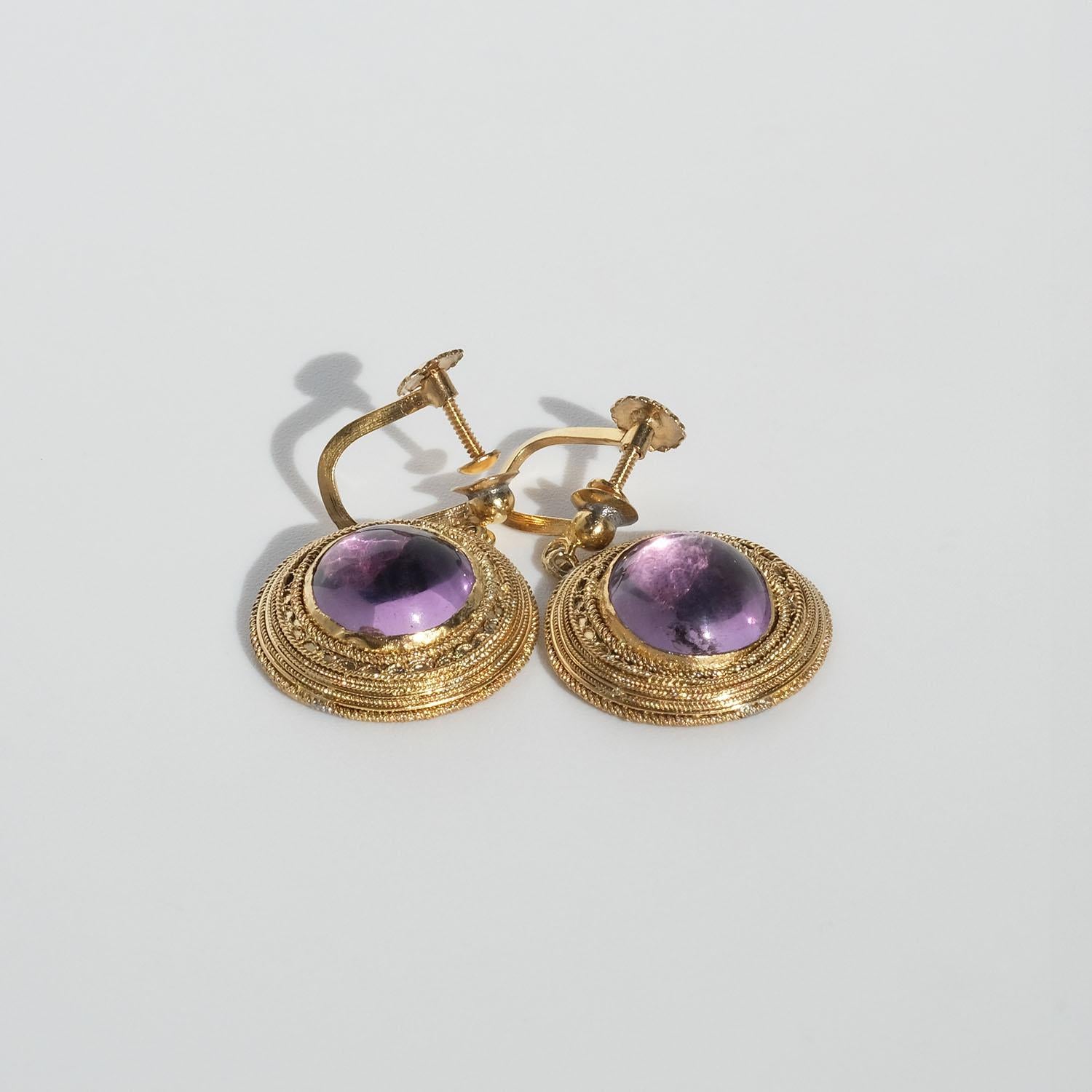 These gilded silver earrings are adorned with cabochon cut amethysts. The framing of the amethysts is beautifully patterned and the earrings have so-called screw backs, like many of the earrings during this period had.

The colourful earrings have a