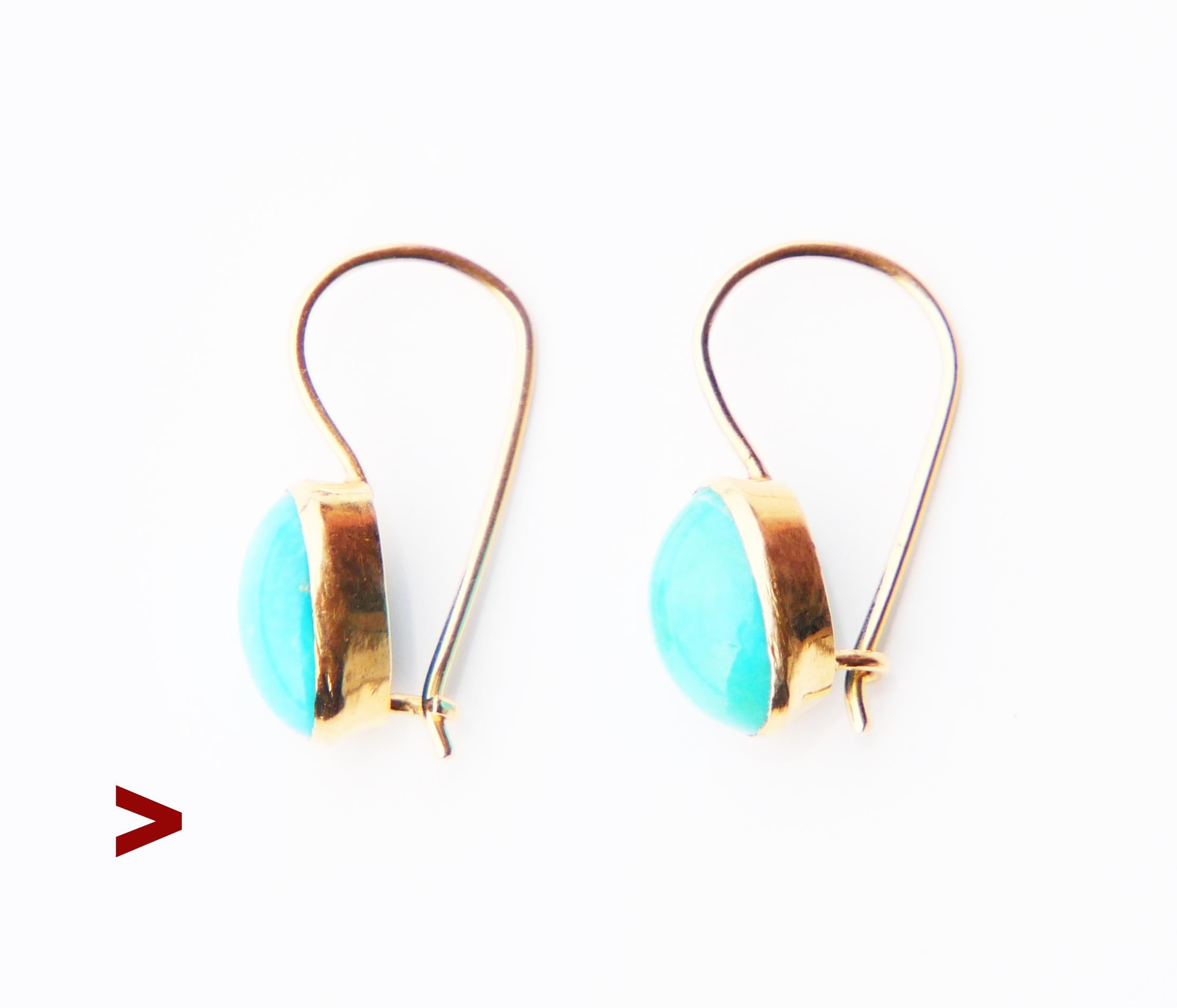 A pair of dangles in 18K Gold with cabochon cut natural Turquoise settings. The color of the stones is light Blue with a faint tint of Green. Each stone measures 9.5mm x 6mm x 4mm deep /ca 2ct. each.

There are no hallmarks on this pair. Metal