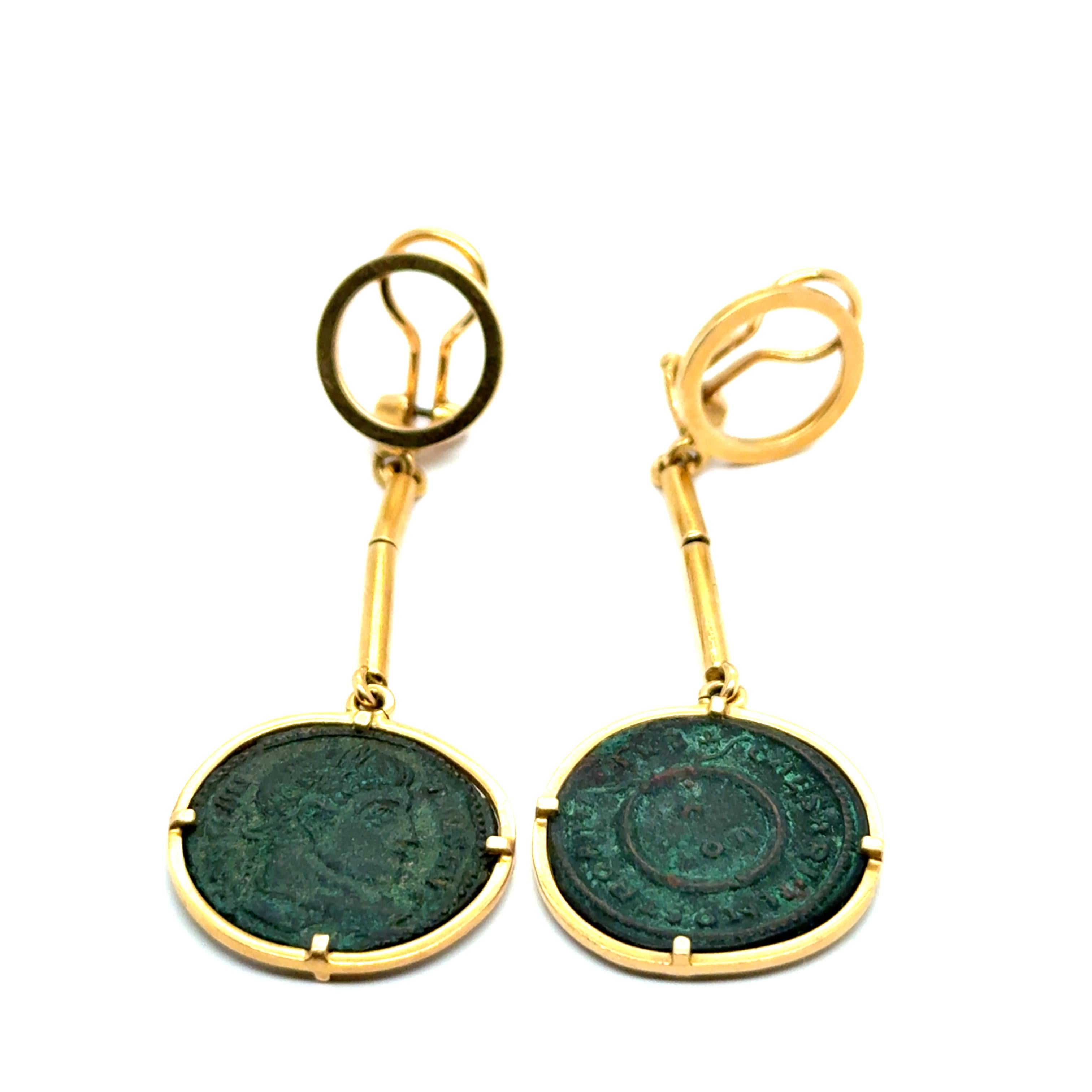 Questi straordinari orecchini antichi fondono l'arte senza tempo con l'intrigo storico. Con autentiche monete antiche incorniciate in elegante oro giallo 18 carati, ogni orecchino racconta una storia silenziosa dell'antichità. 

La ricca patina