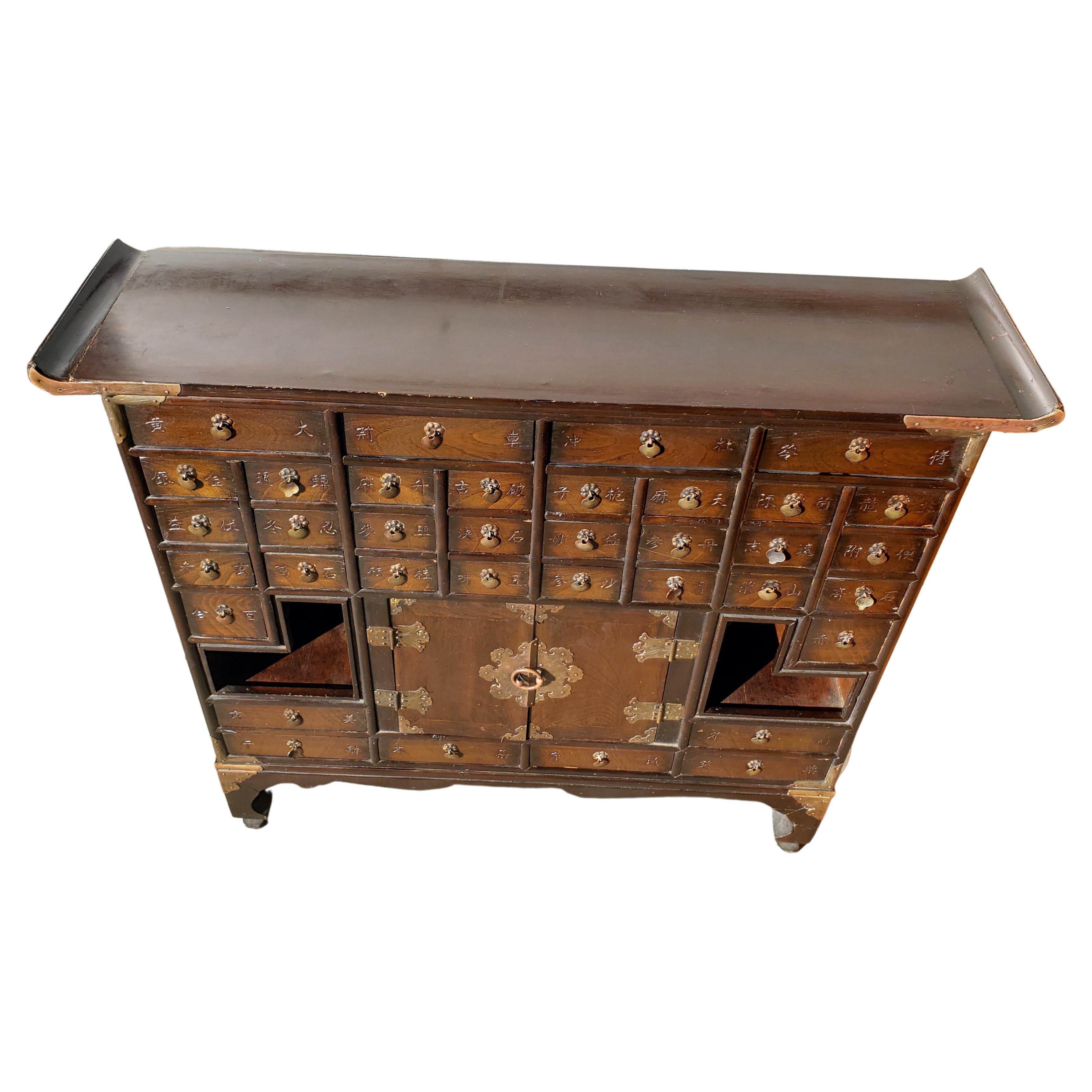 Authentic east Asian herbal medicine chest hand crafted in a classic Korean / Japanese antique design, with 36 miniature drawers, traditionally used for medicinal powders, minerals, roots and herbs. Finished in a richly grained dark stained Elmwood