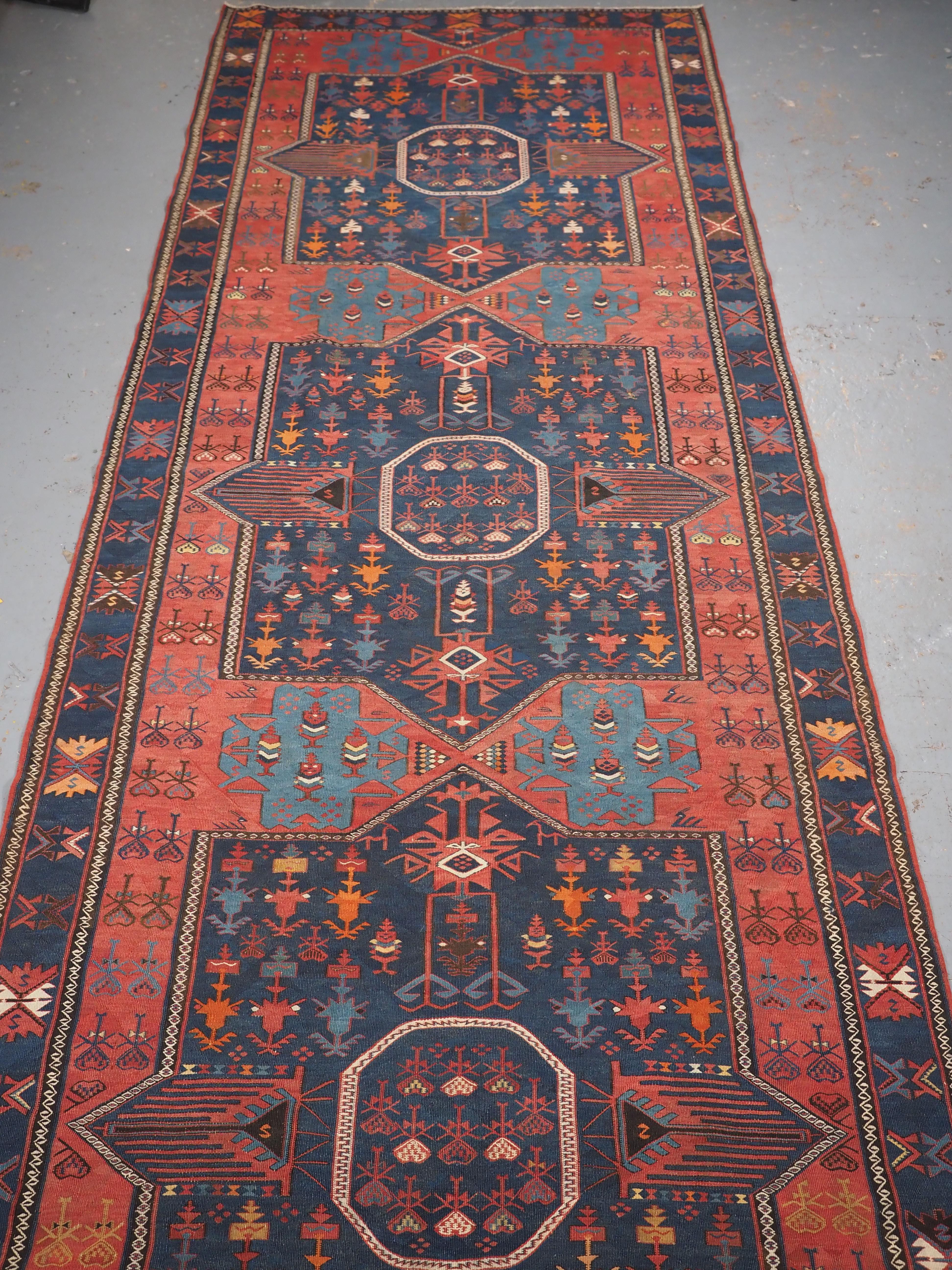 Size: 18ft 5in x 5ft 0in (562 x 153cm).

Antique East Caucasian Avar kilim of very large size and classic design.

Circa 1900.

A good example of a traditional Avar kilim from Dagestan in the Eastern Caucasus. The soft red ground off sets the bold