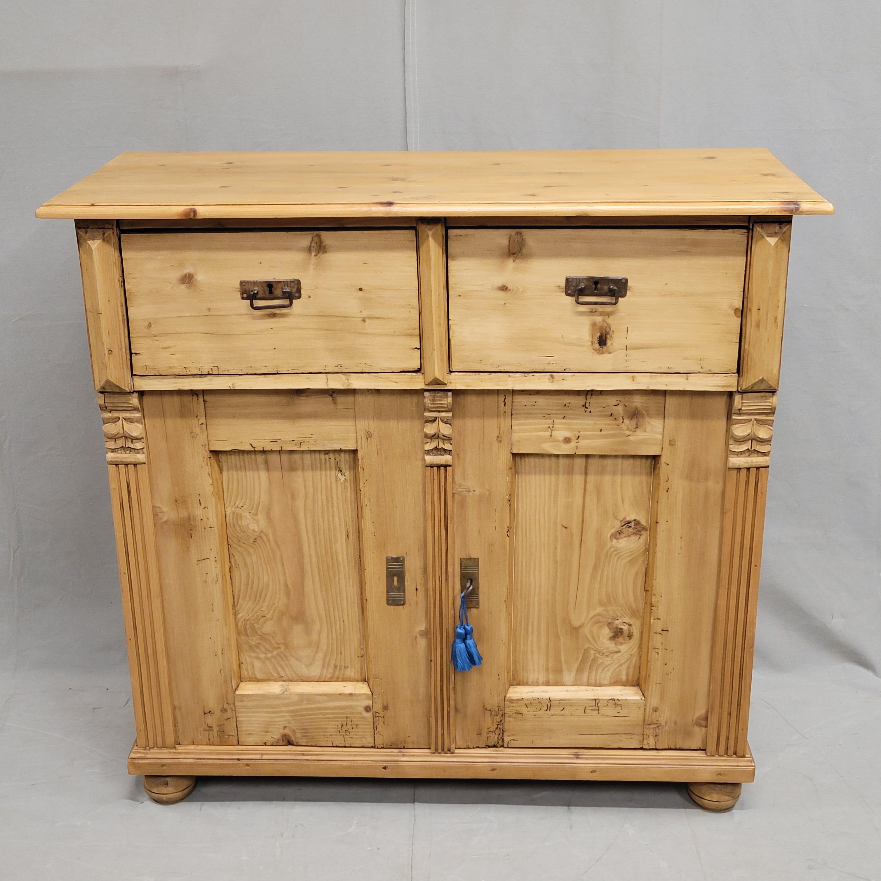 A charming and functional antique early 1900s Eastern European rustic natural pine buffet / sideboard. Compartment underneath with doors combined with two drawers offers ample storage. Key is functional, serving as a pull for the right door and