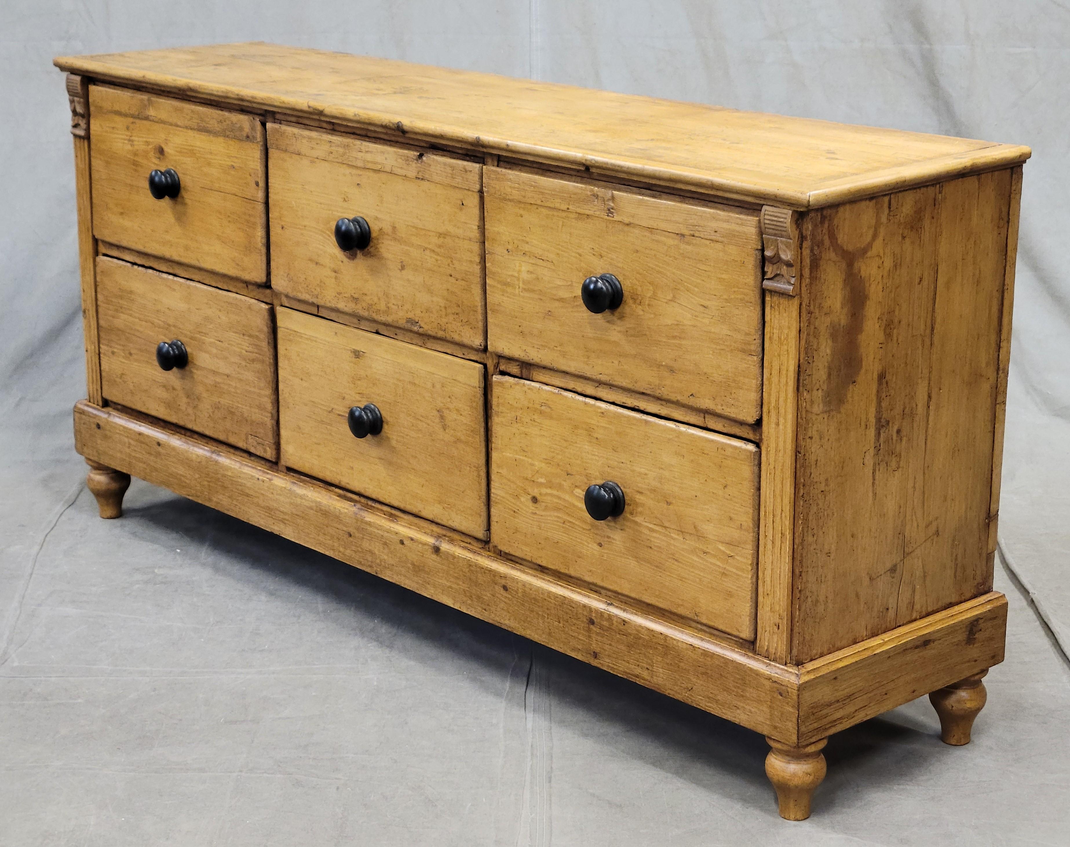 A gorgeous antique Eastern European rustic pine credenza sideboard apothecary with six drawers which offer a good amount of storage. Note the rustic nature of the pine with old wormholes and imperfections which add to the charm of this piece. Hand